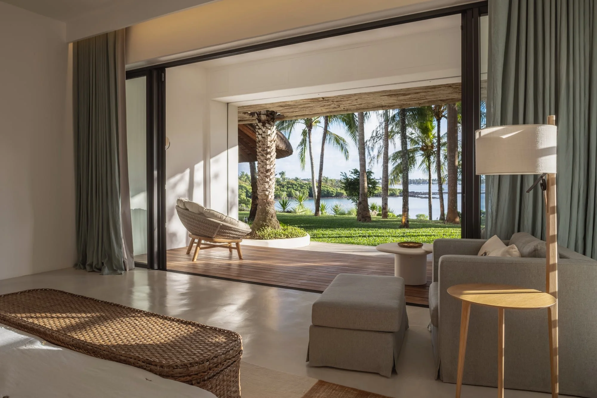 Serene bedroom opening onto a timber terrace and lagoon view