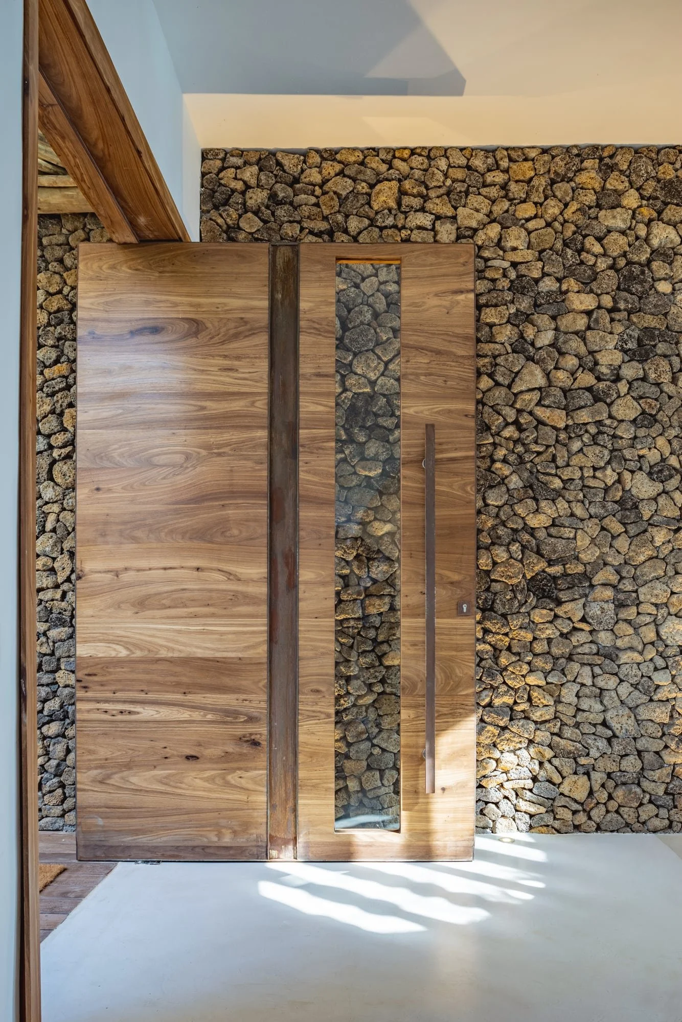 Monumental timber entrance door set within a natural stone wall