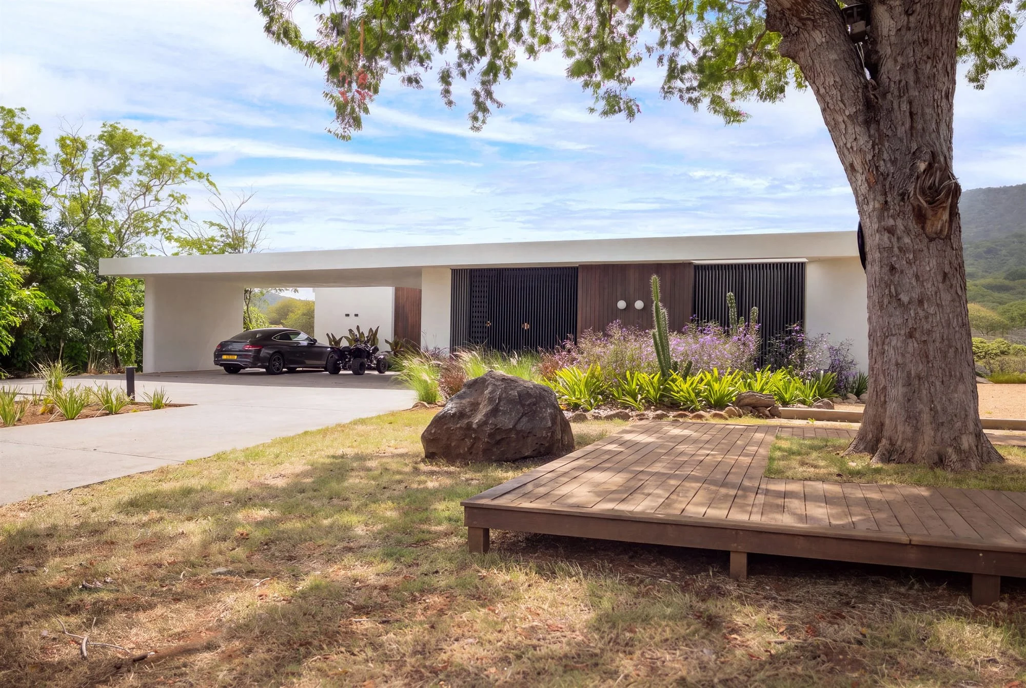 Krono Residence front facade framed by garden and timber deck