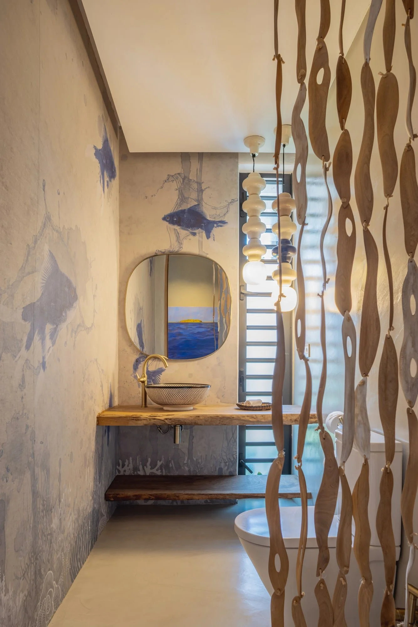 Powder room vanity framed by a sculptural carved timber screen