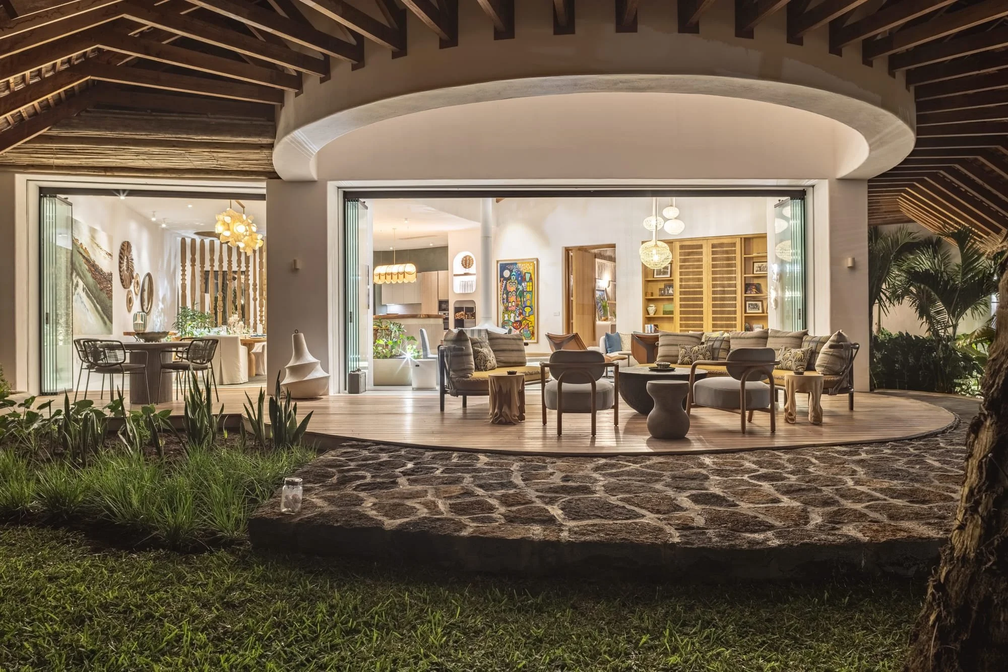 Evening view of a covered terrace opening onto the villa interior