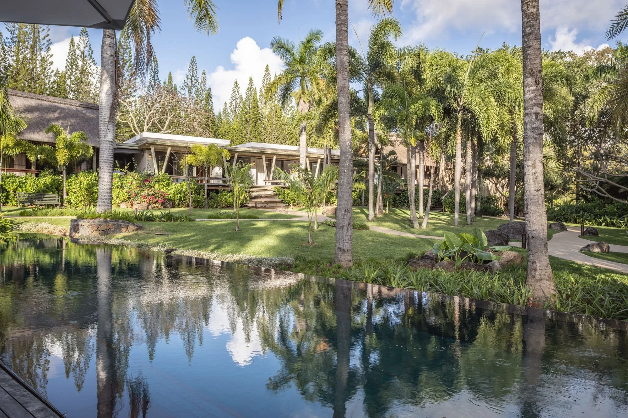 Reflection pool and villa pavilions set within a tropical garden