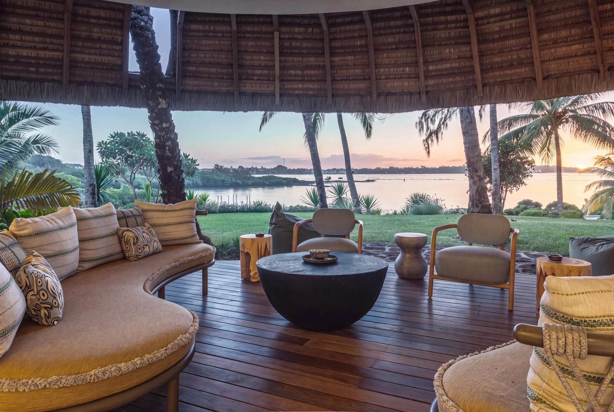 Covered outdoor lounge overlooking the lagoon at sunset