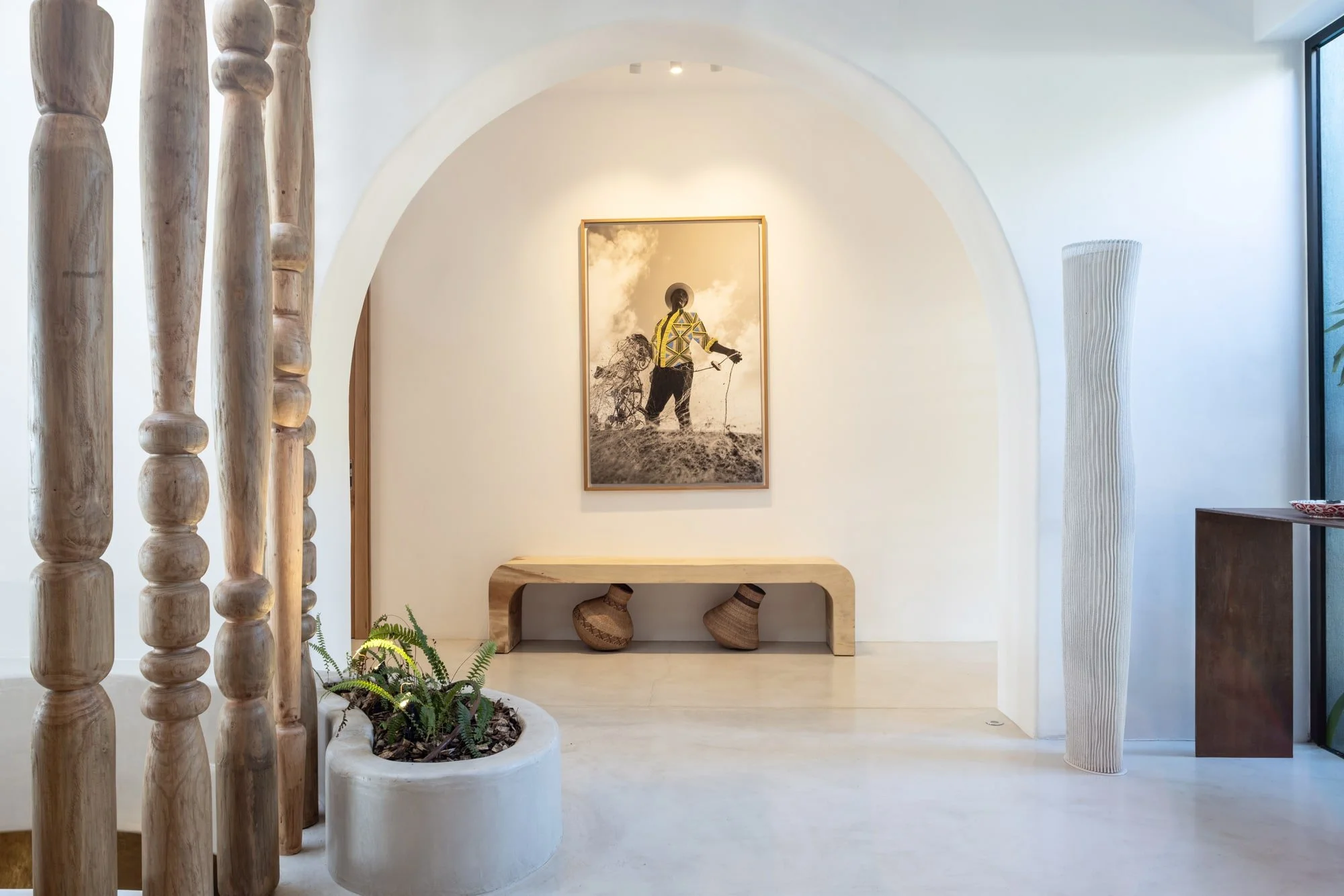 Minimal arched alcove with artwork and a handcrafted timber bench