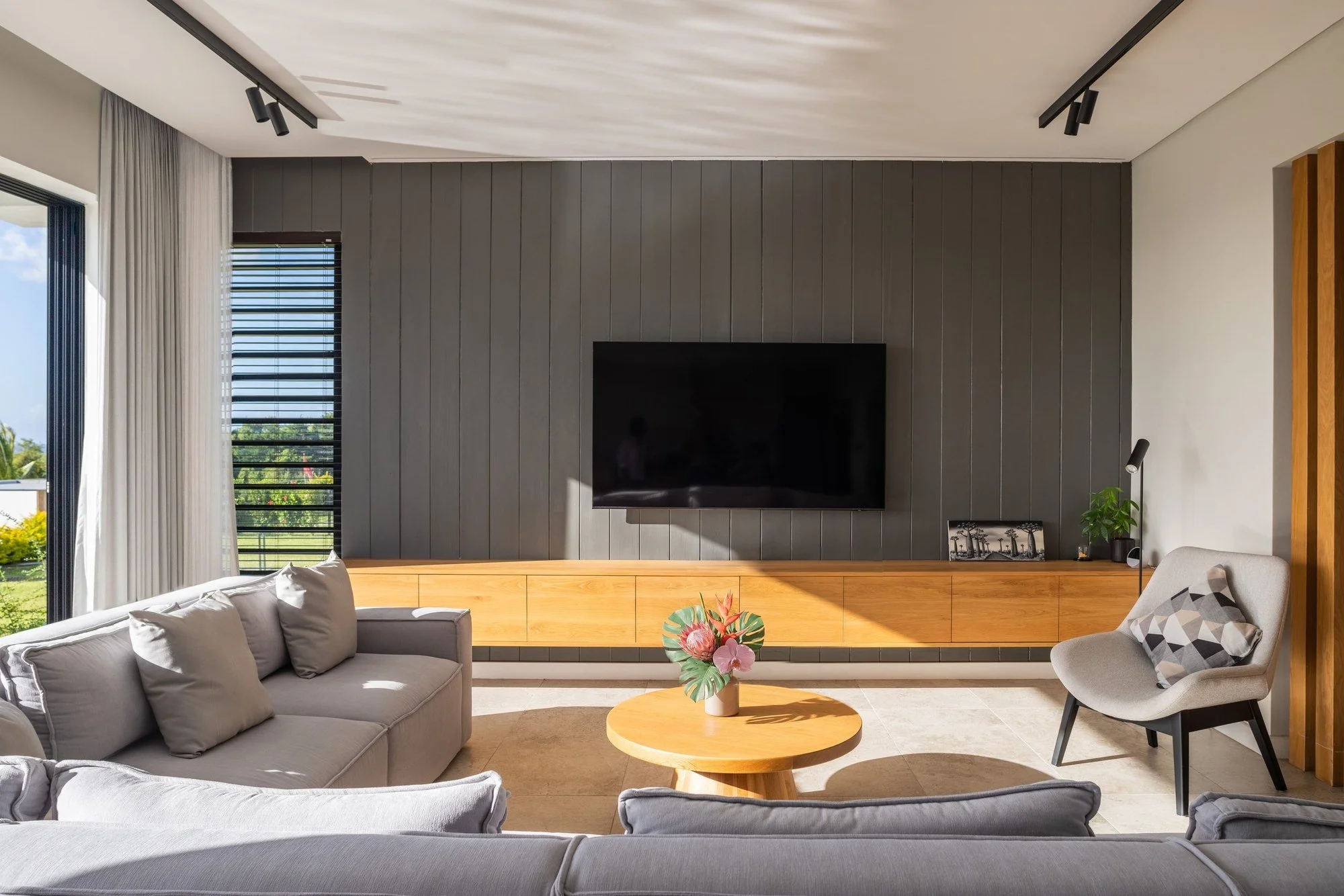 Salon contemporain de la Chikooree House avec mobilier sur mesure et finitions chaleureuses.