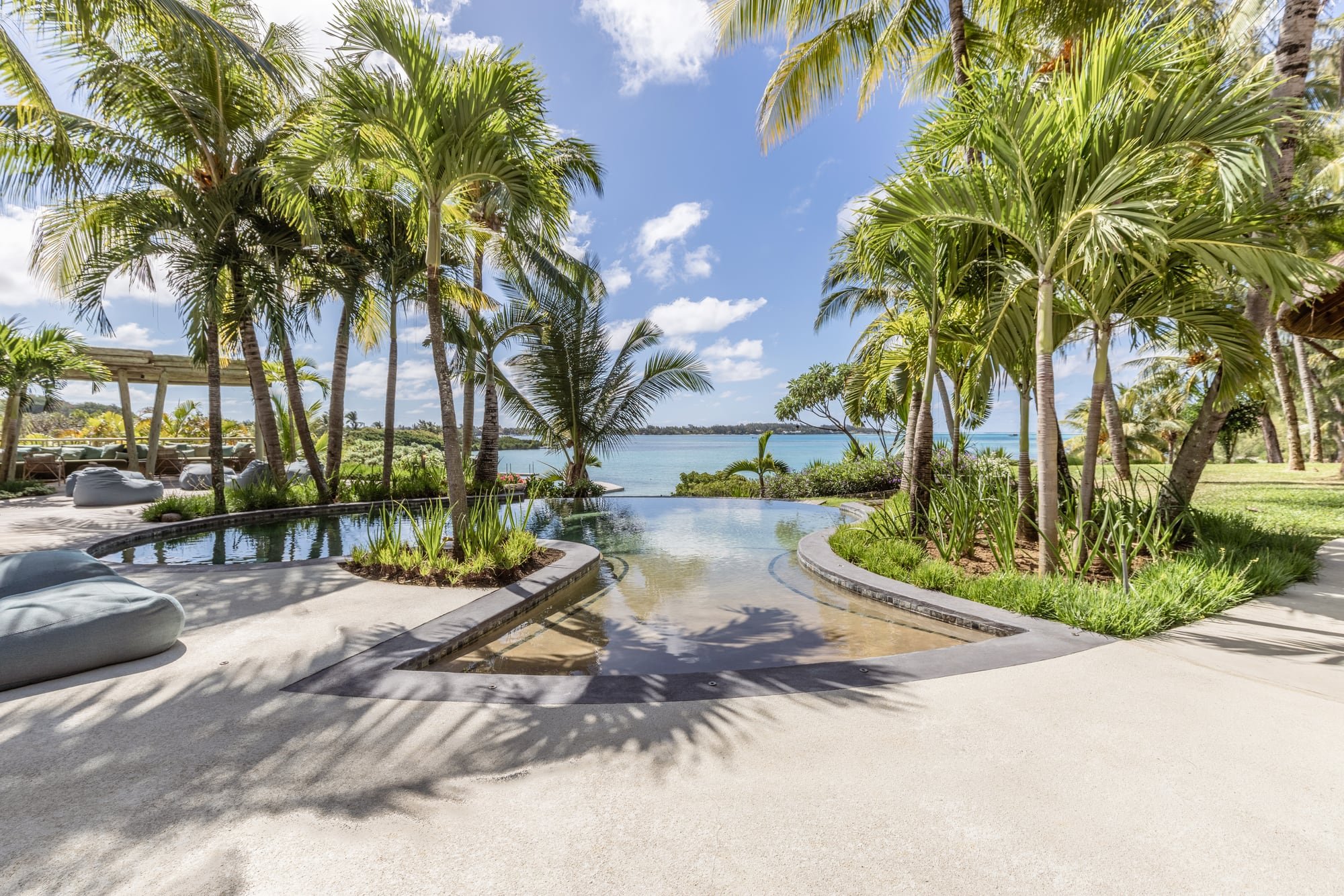 Infinity pool surrounded by palms with a panoramic lagoon view
