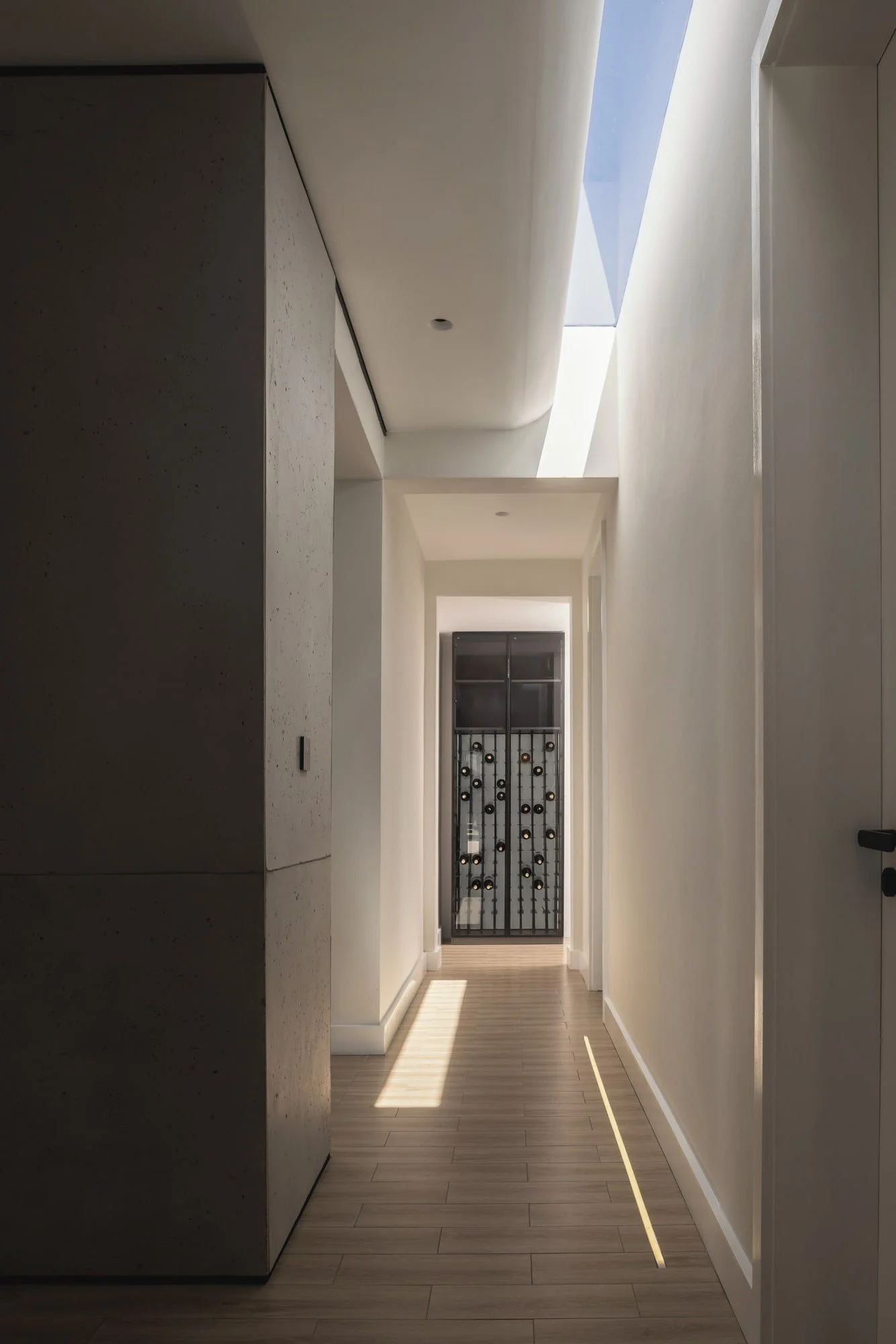 Skylit corridor with linear lighting at Krono Residence