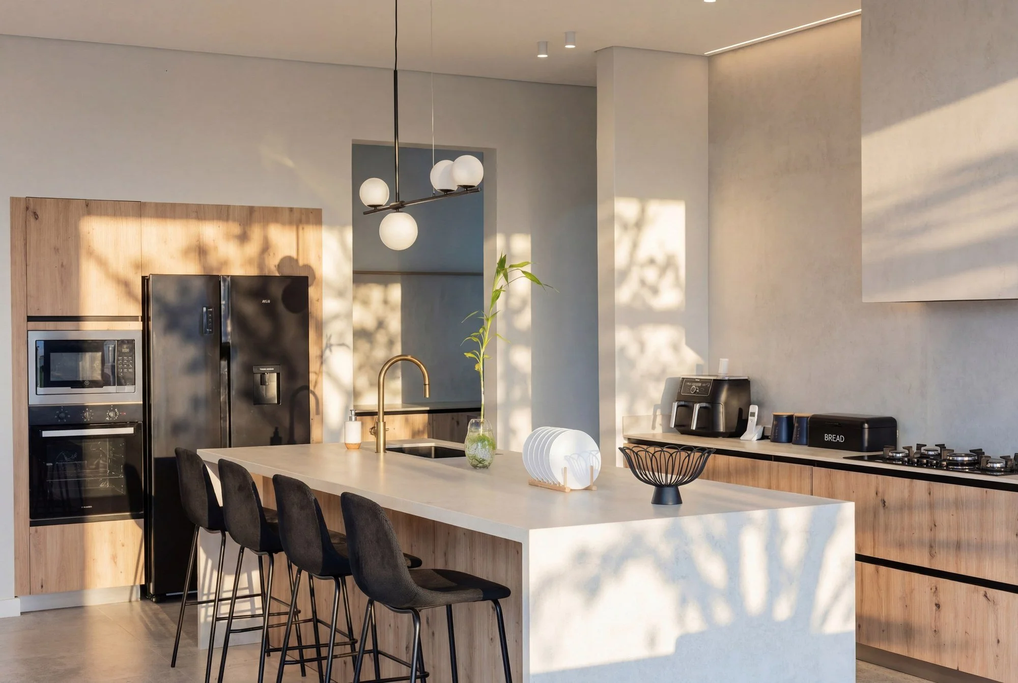 Cuisine contemporaine ouverte de la Chikooree House, alliance de pierre claire, bois et lumière naturelle.