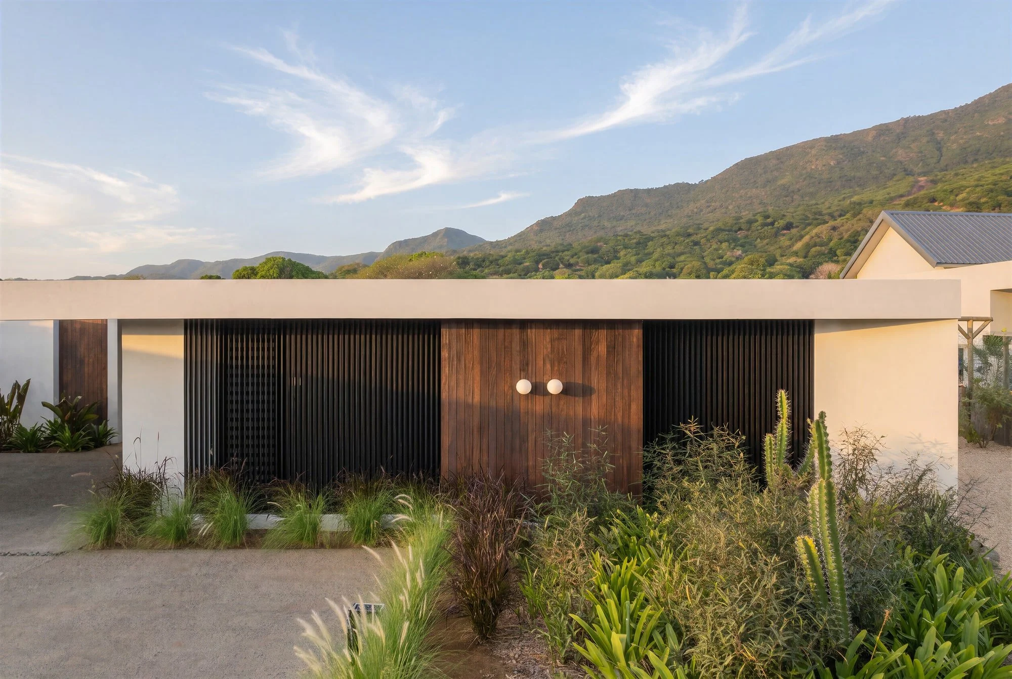 Low-profile facade of Krono Residence against the Mauritian mountains