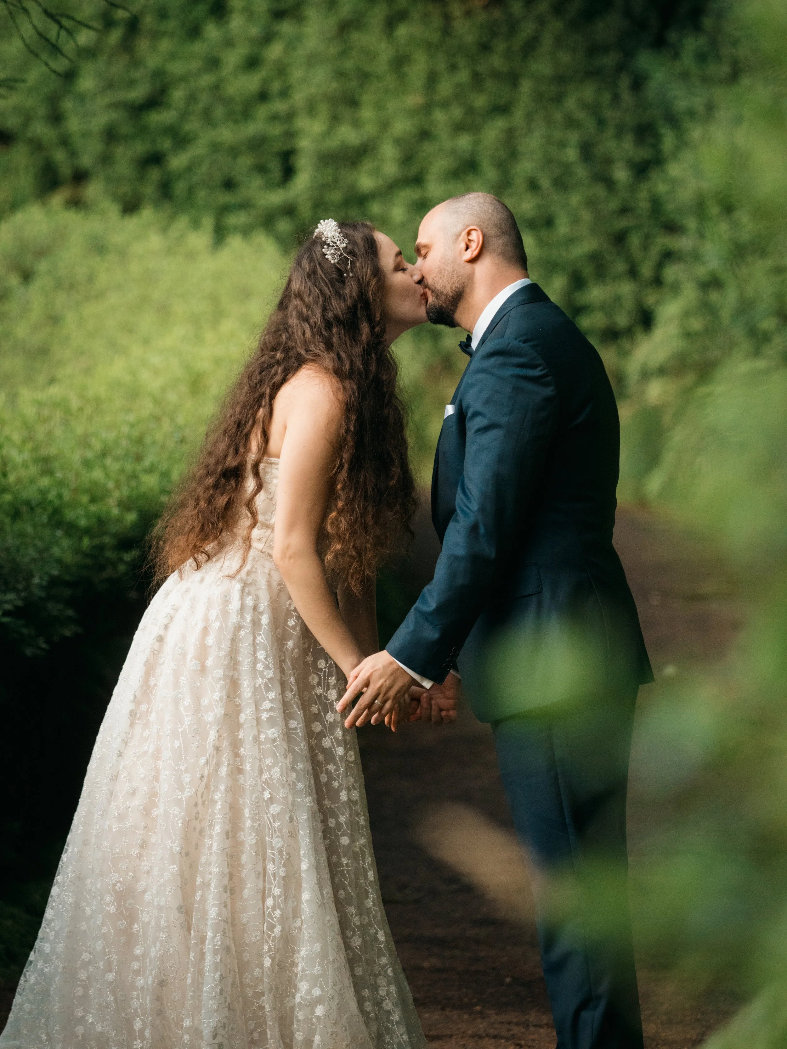 Bride and groom kissing during an elopement photoshoot surrounded by lush green nature in the Azores