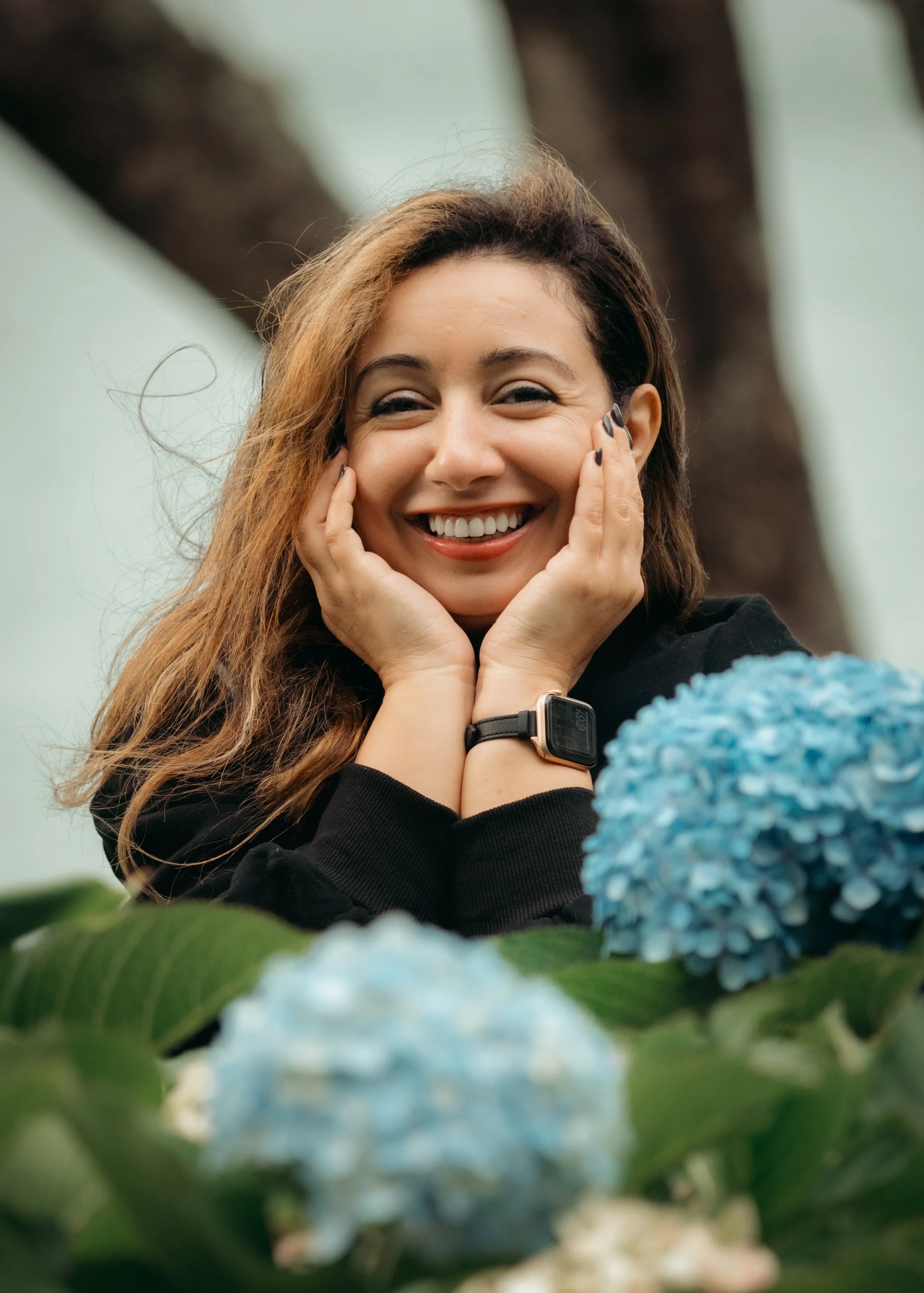 Smiling woman surrounded by hydrangeas during a photoshoot with an Azores photographer in São Miguel Island