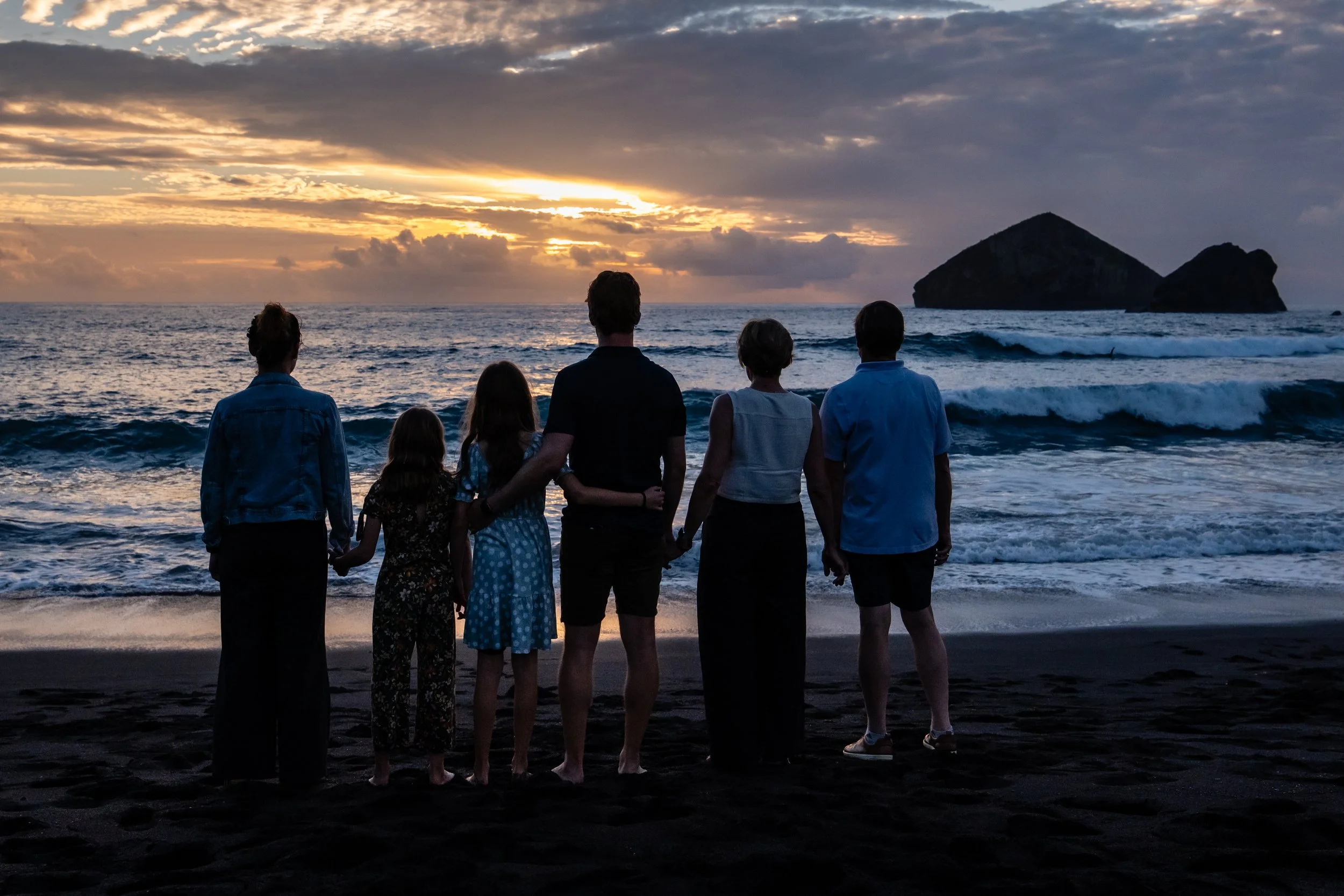 Family standing on a beach at sunset in São Miguel, Azores, during a vacation photo tour