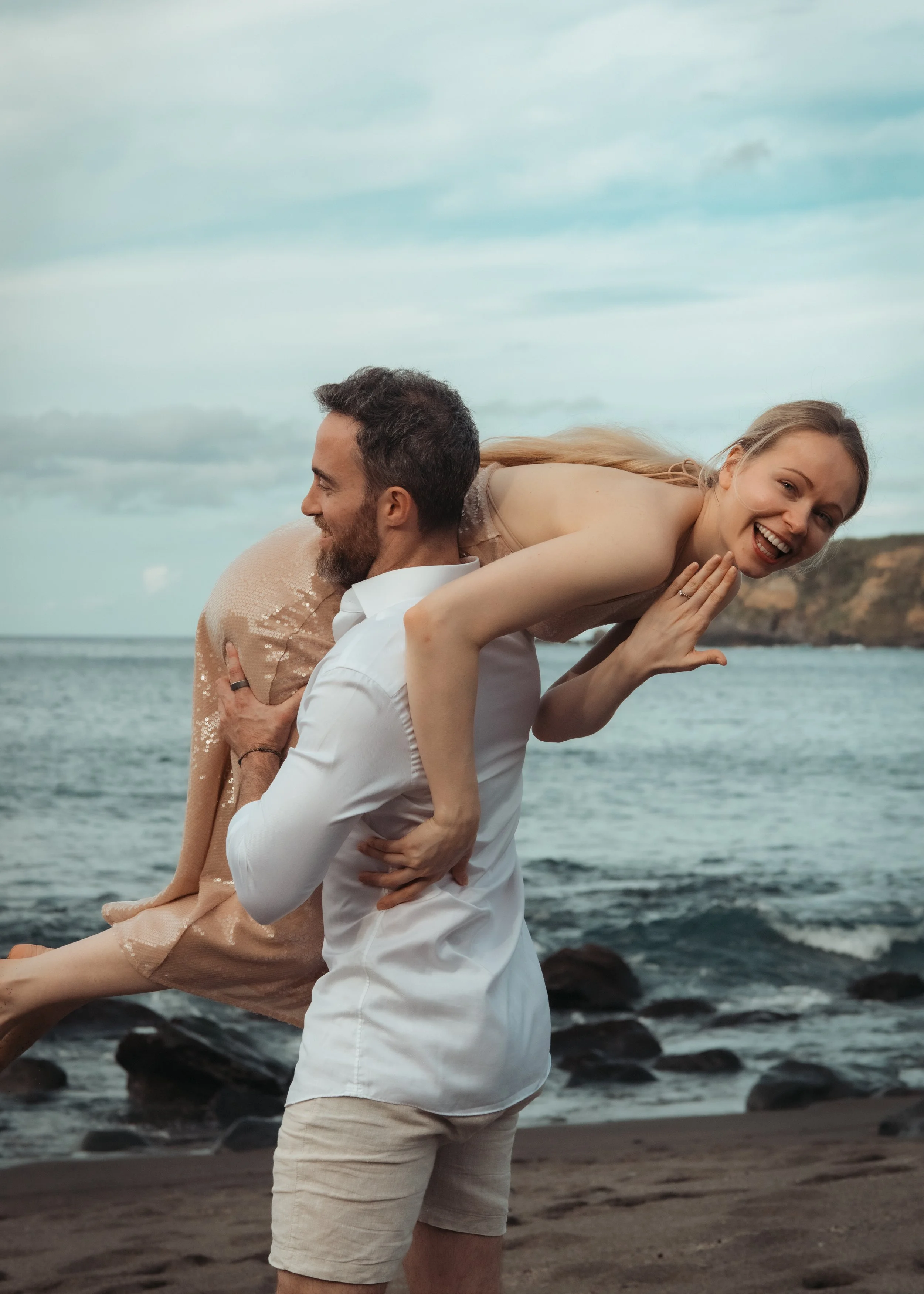 Couple laughing and having fun during a relaxed private photo tour by the ocean in São Miguel, Azores