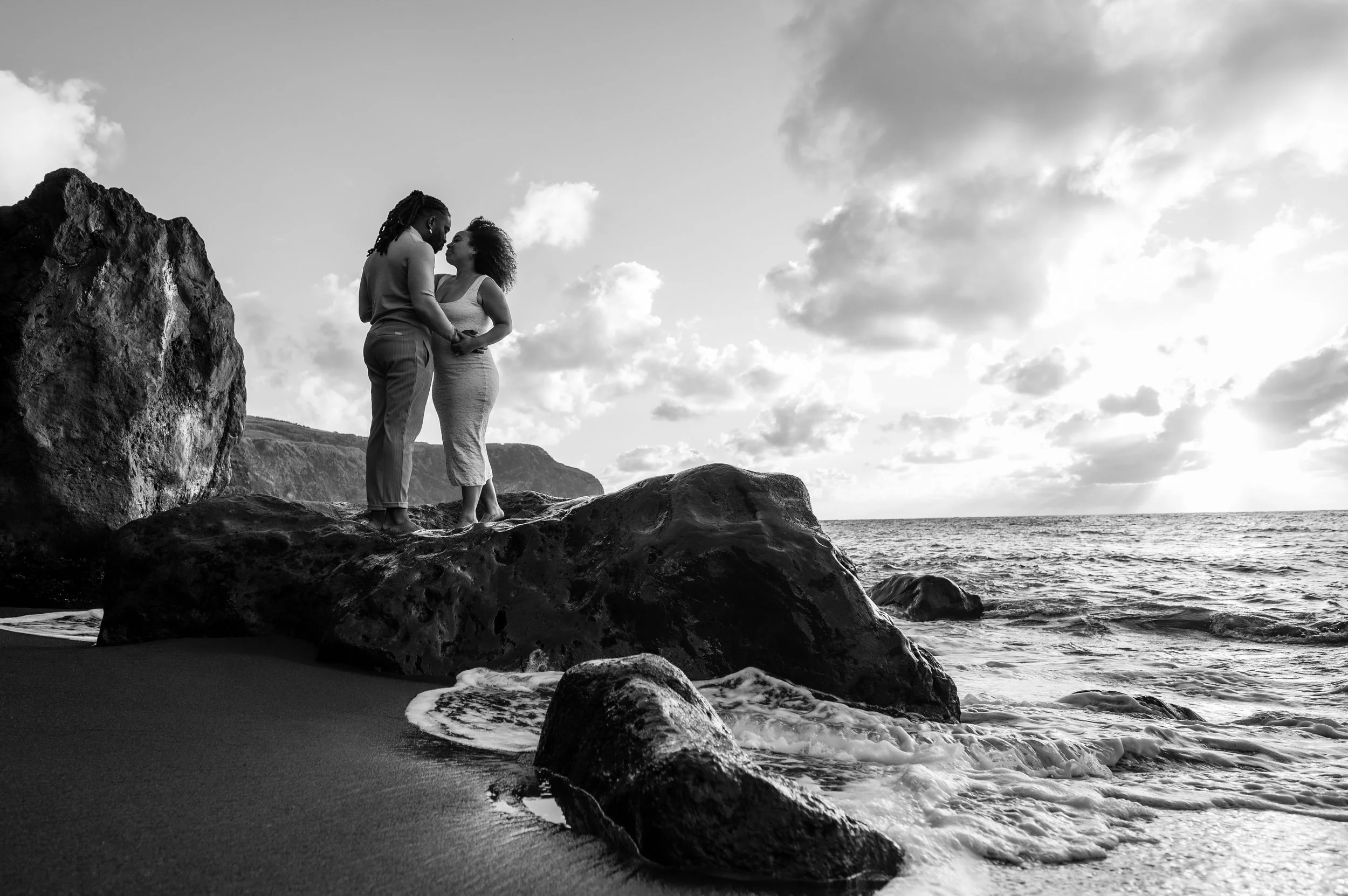 Azores proposal on a black sand beach with couple standing on volcanic rocks during a private photo session in São Miguel