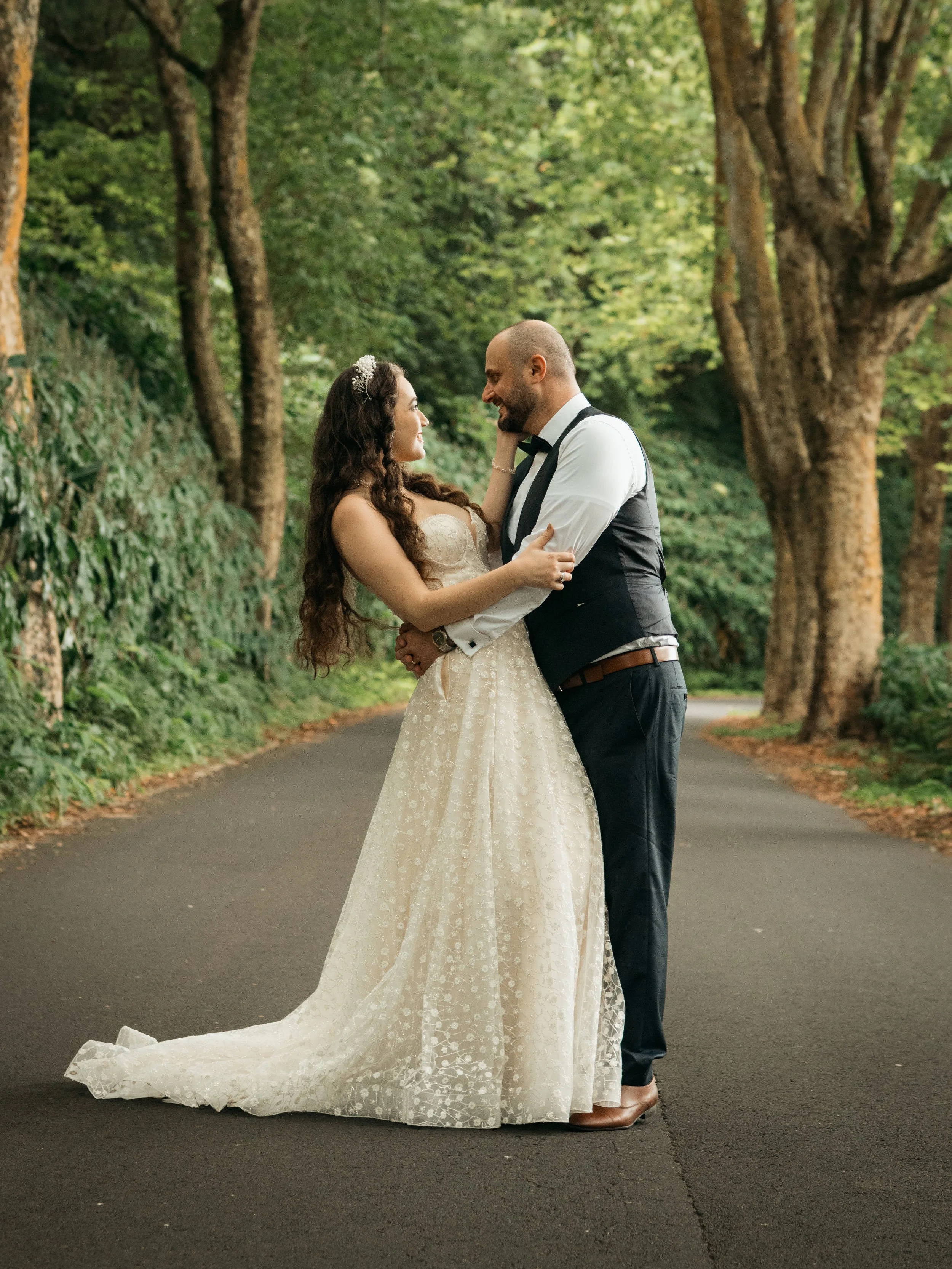 Bride and groom sharing an intimate moment on a quiet forest road in the Azores during their elopement photoshoot