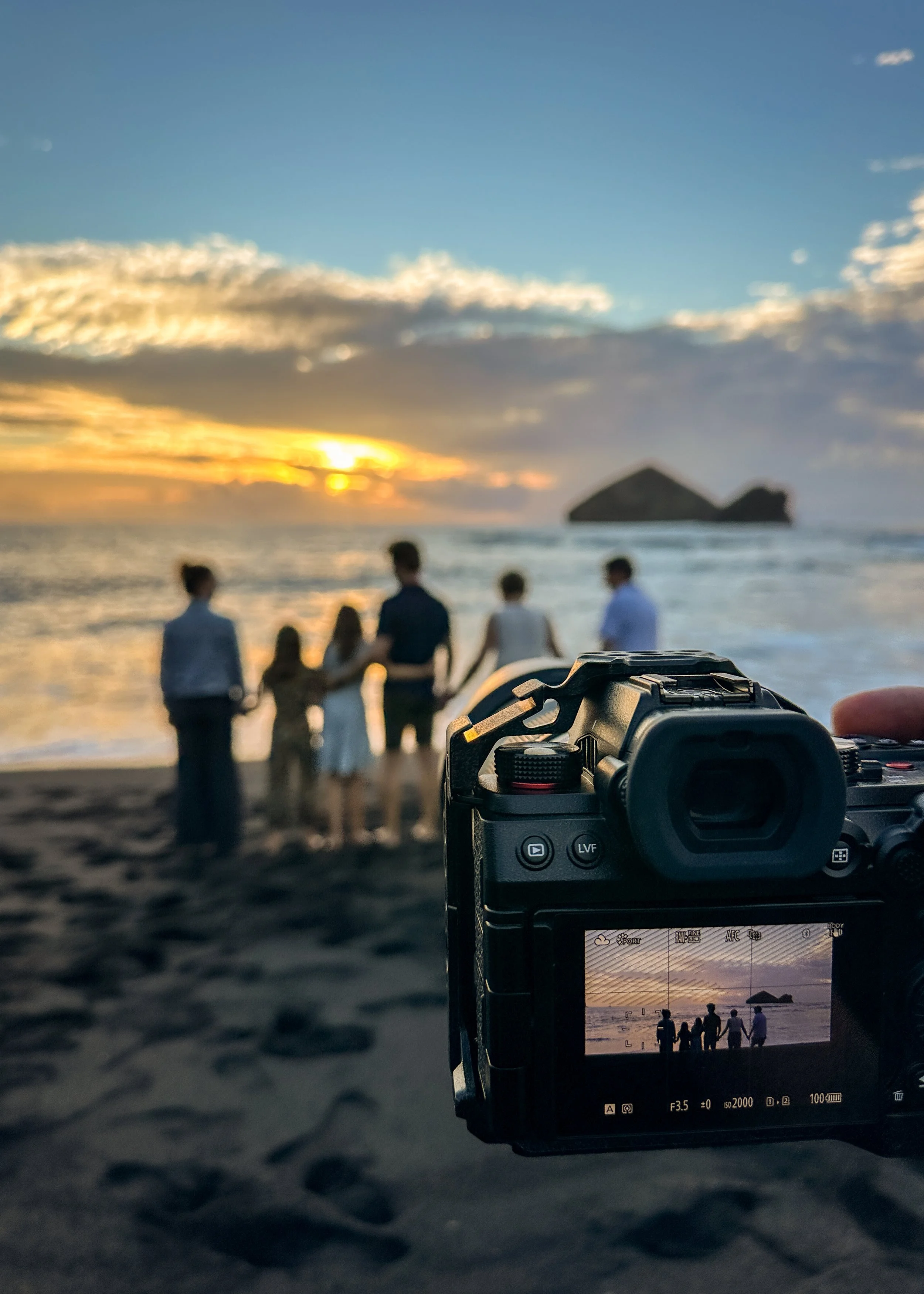 Behind the scenes view of a family photo session at sunset on Mosteiros beach in São Miguel, Azores