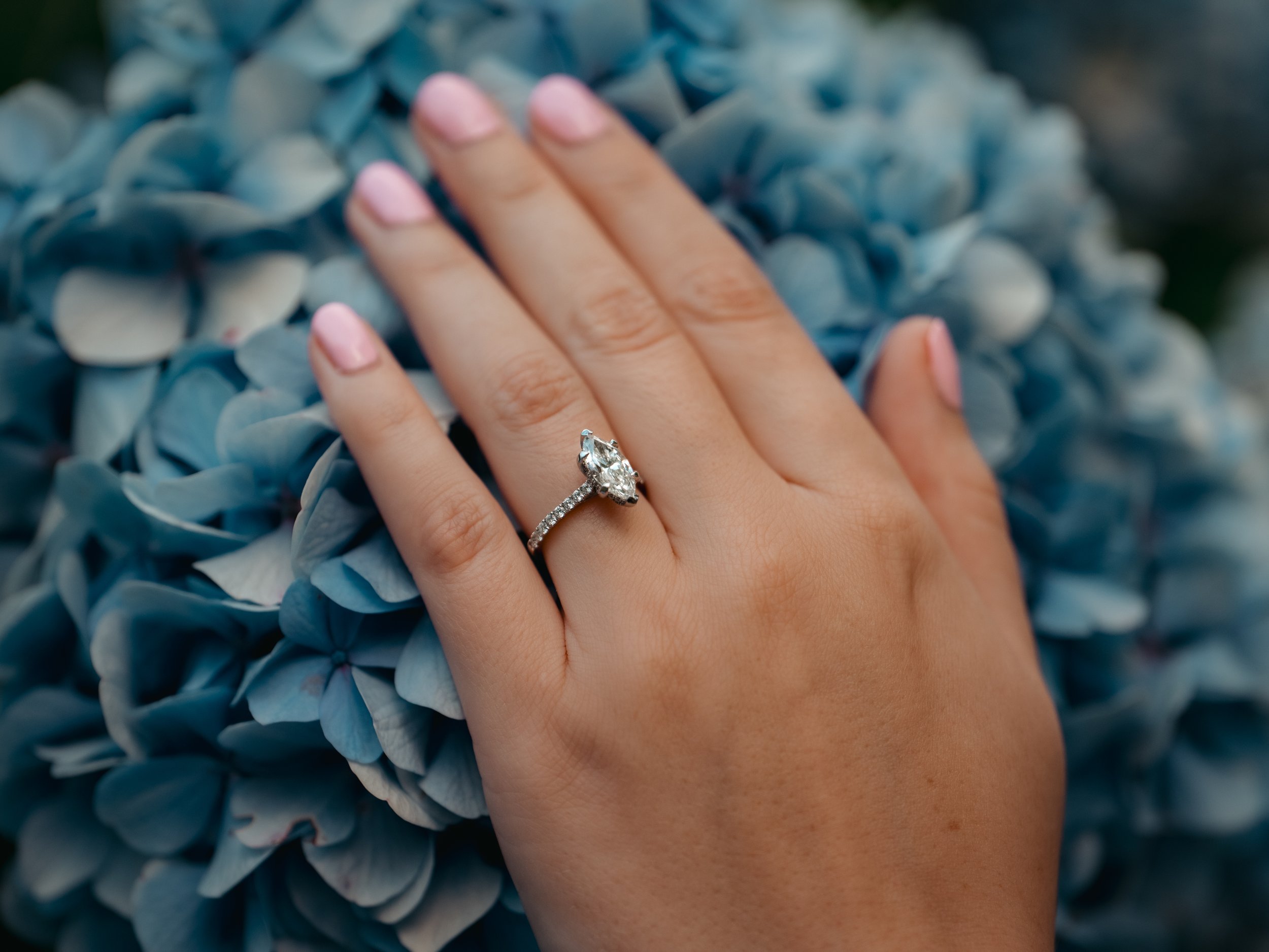 Engagement ring on hand over blue hydrangeas in São Miguel Azores after proposal photoshoot
