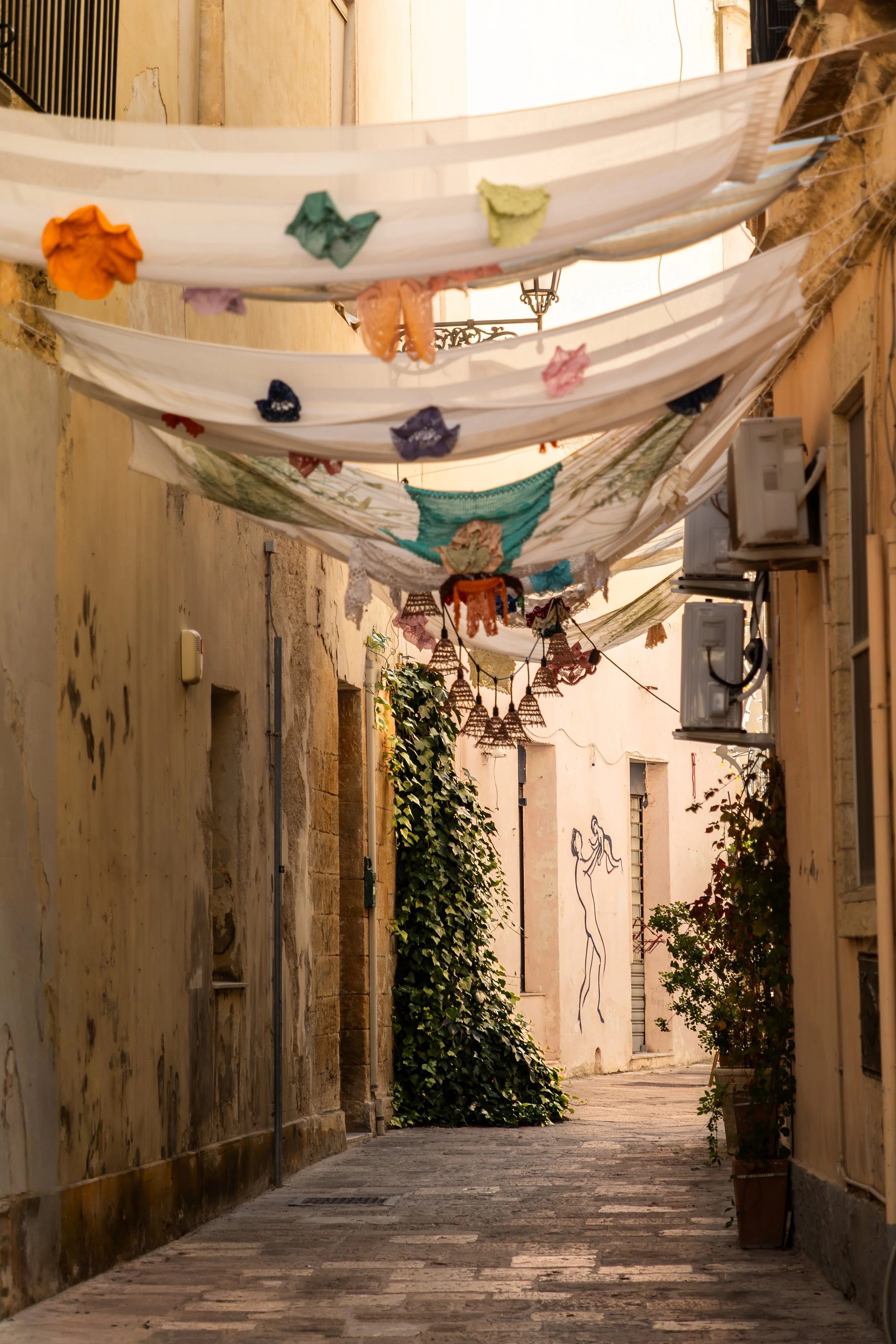 A Mural of a Father and Child is the focal point of this fabric-framed Italian alleyway.