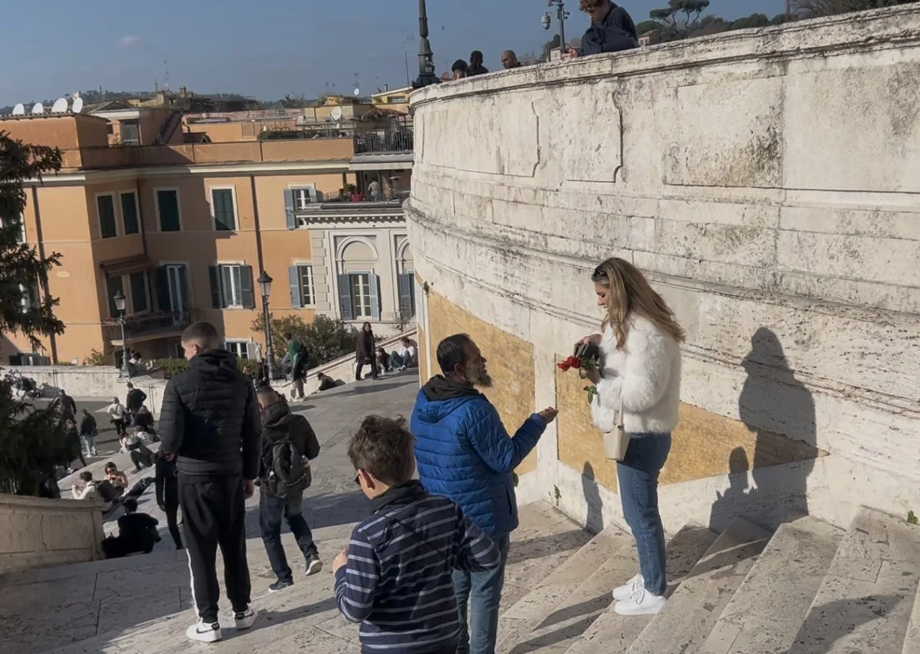 A rose seller approaching tourists on the Spanish Steps in Rome