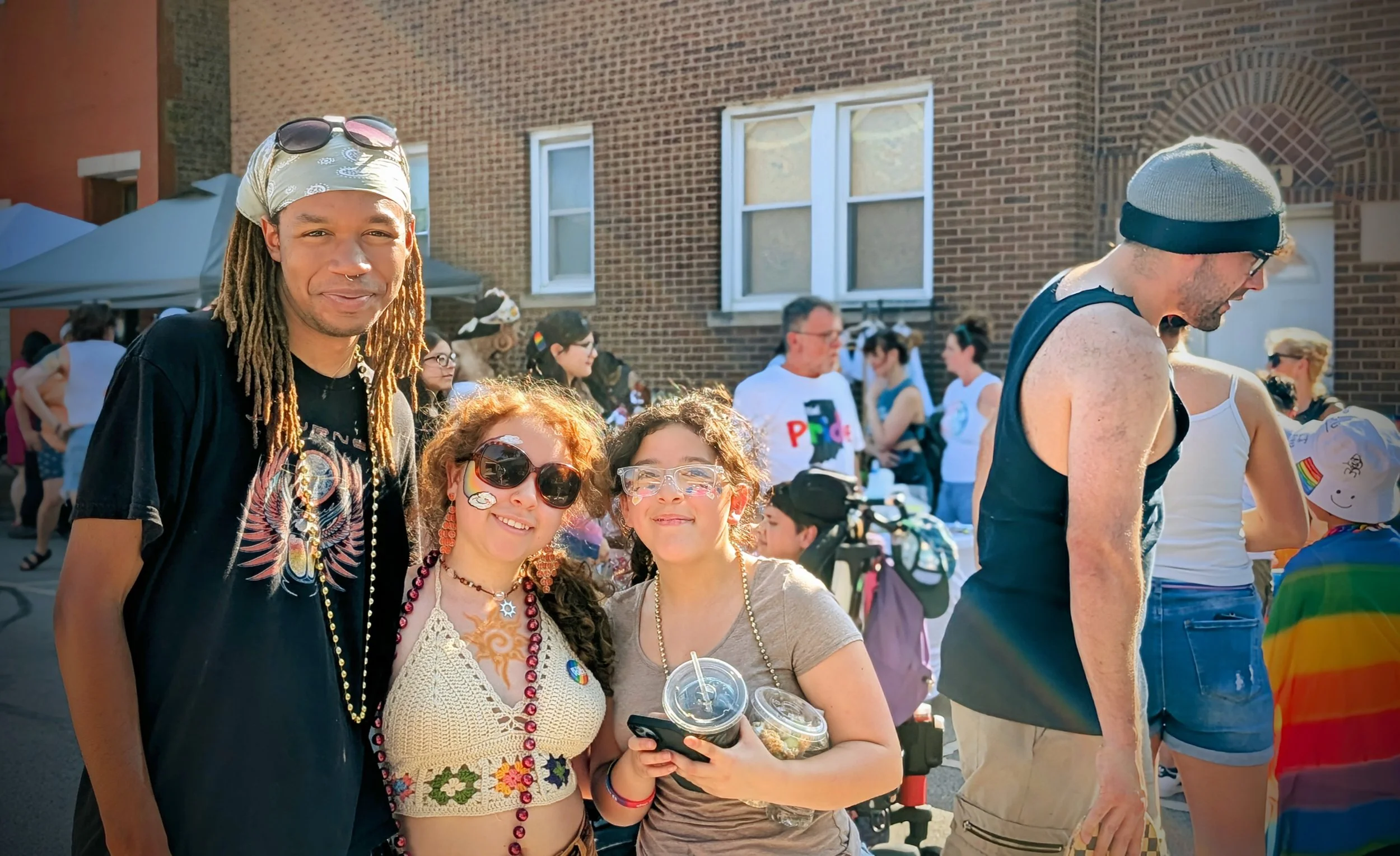 a woman holds a toddler in her arms while giving a peace sign with a teenager next to her