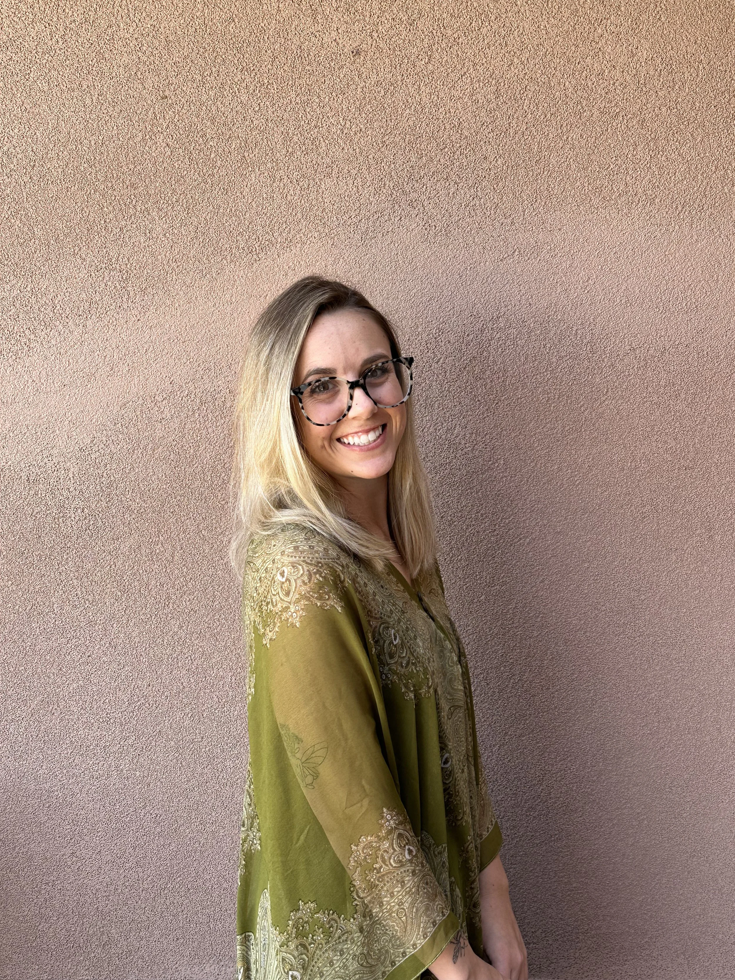 white woman with a green flowy shirt smiling