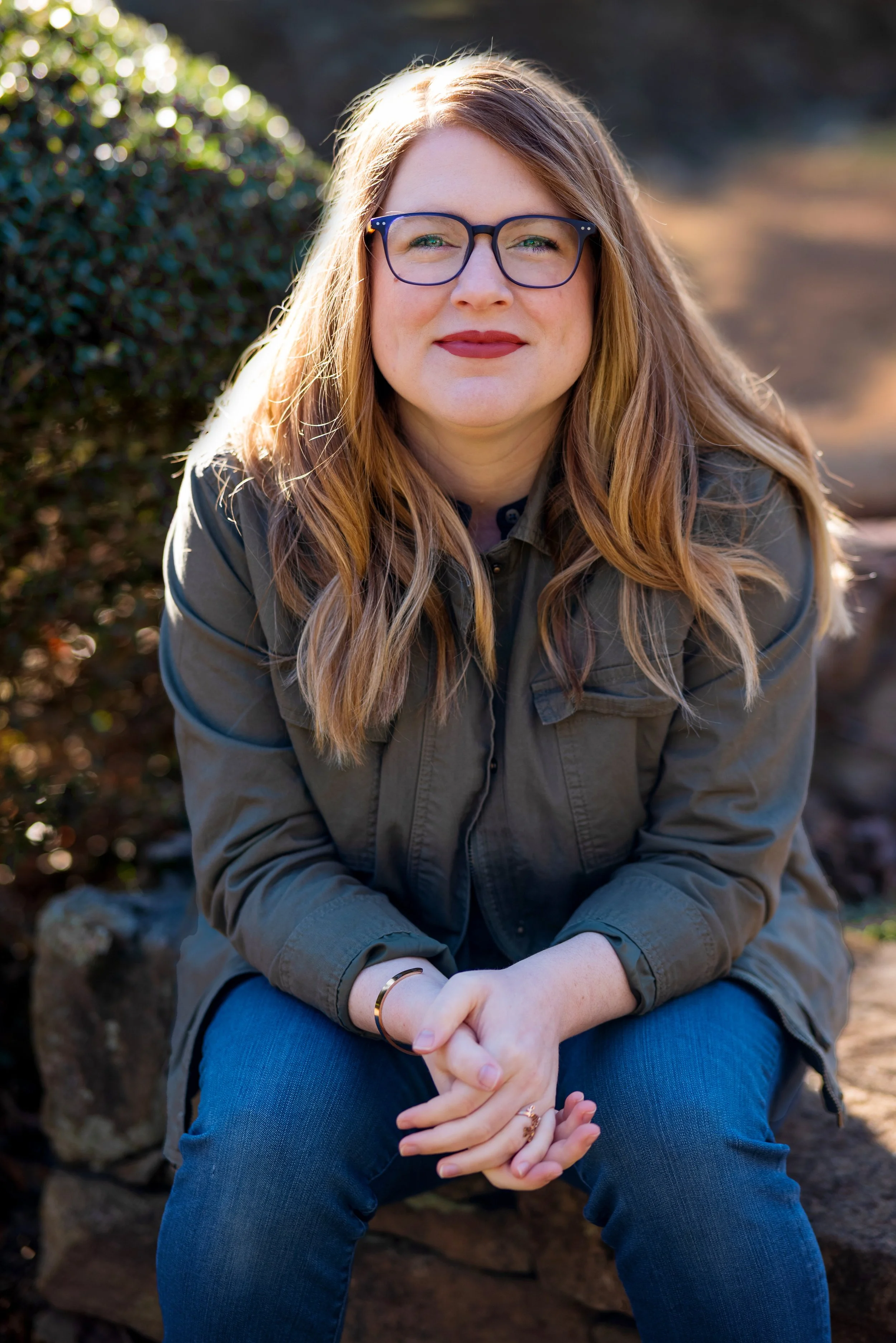 A headshot with a blurred nature background of Emilea Richardson, LMFT a therapist specializing in divorce, anxiety, and emotional eating in Greenville, SC.