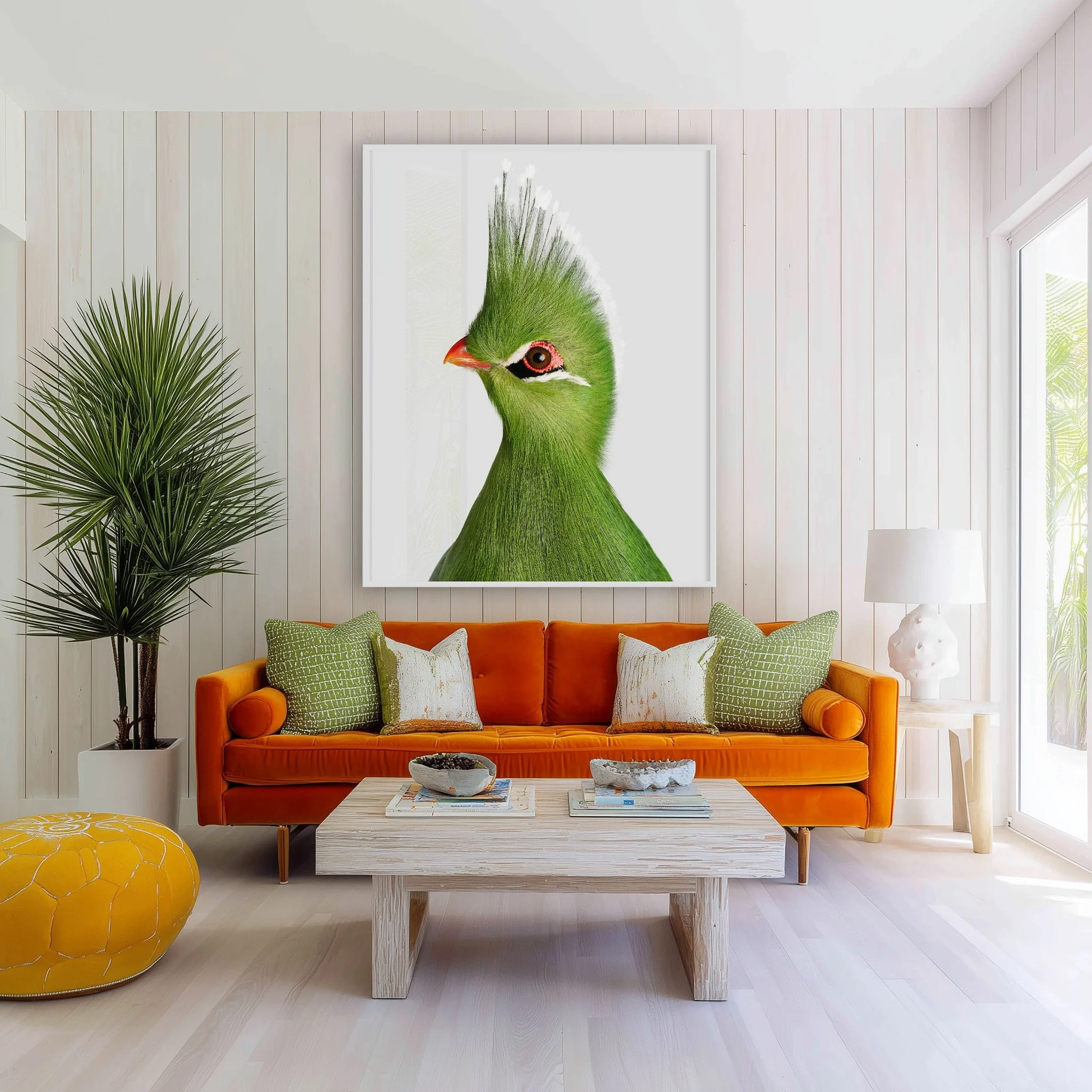 Livingstone's Turaco portrait by Randal Ford displayed above an orange sofa in a bright family room