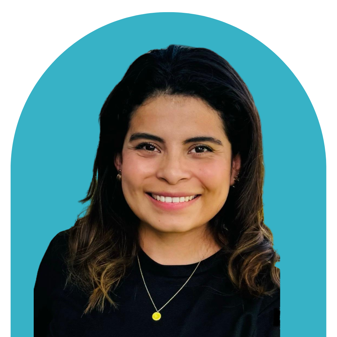 A woman with dark hair smiling, wearing a black top and a gold necklace, against a teal background.