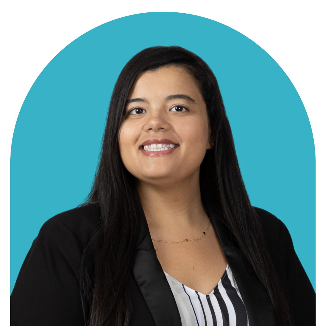 A woman with long black hair smiling, wearing a black blazer and a striped blouse, against a blue background.