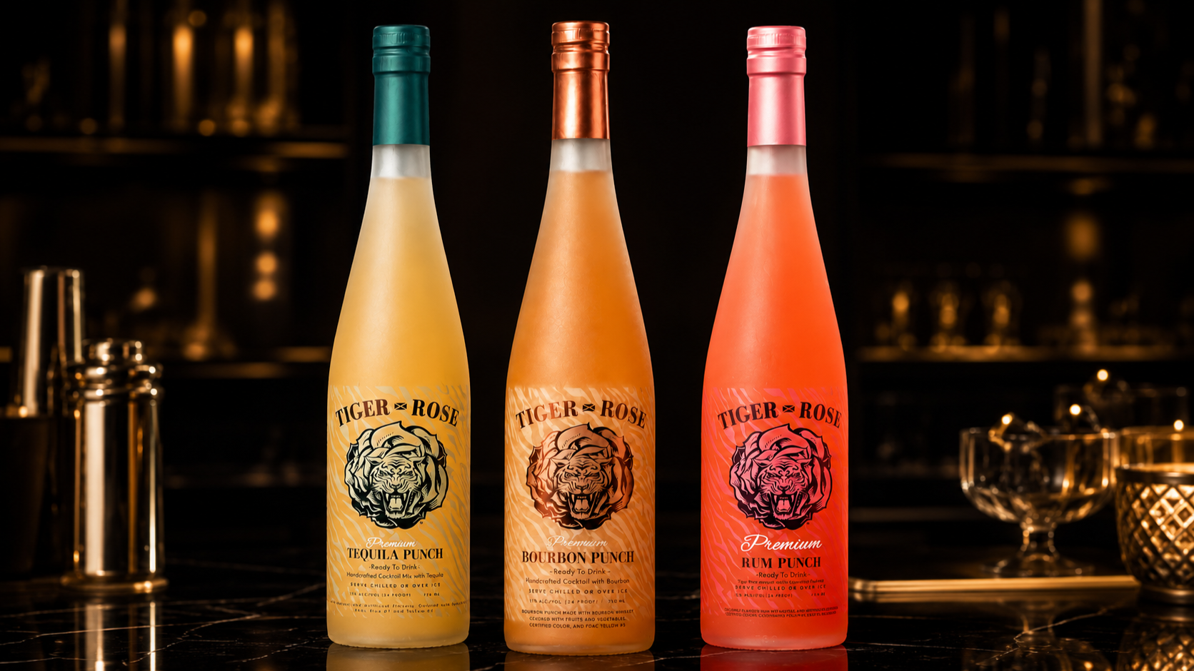 Three bottles of Tiger Rose flavored drinks on a dark bar counter, with glasses and bar tools in the background, featuring a tiger and rose logo on each bottle.