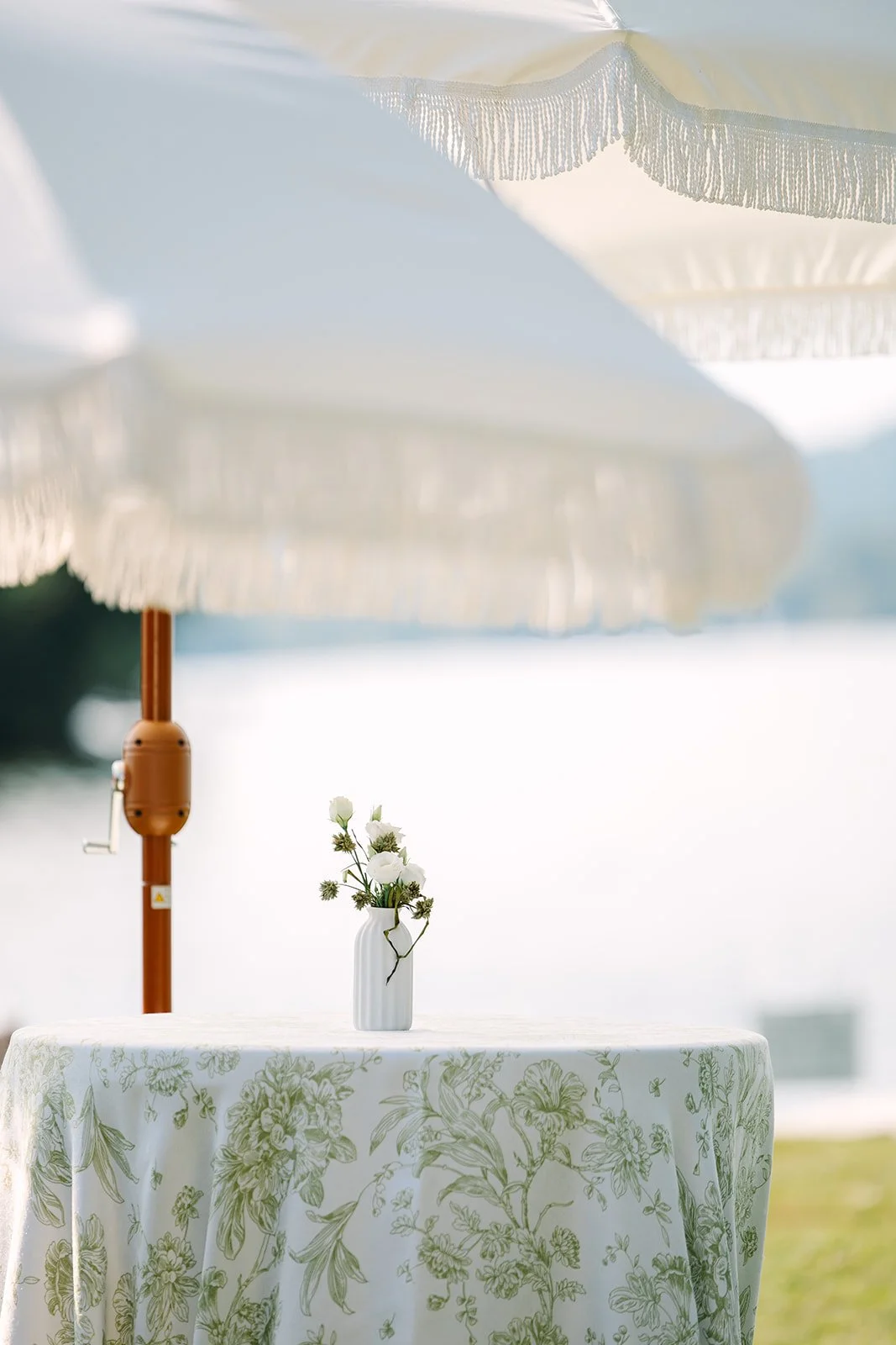 White fringe umbrella with base

Photo by Juniper Studios