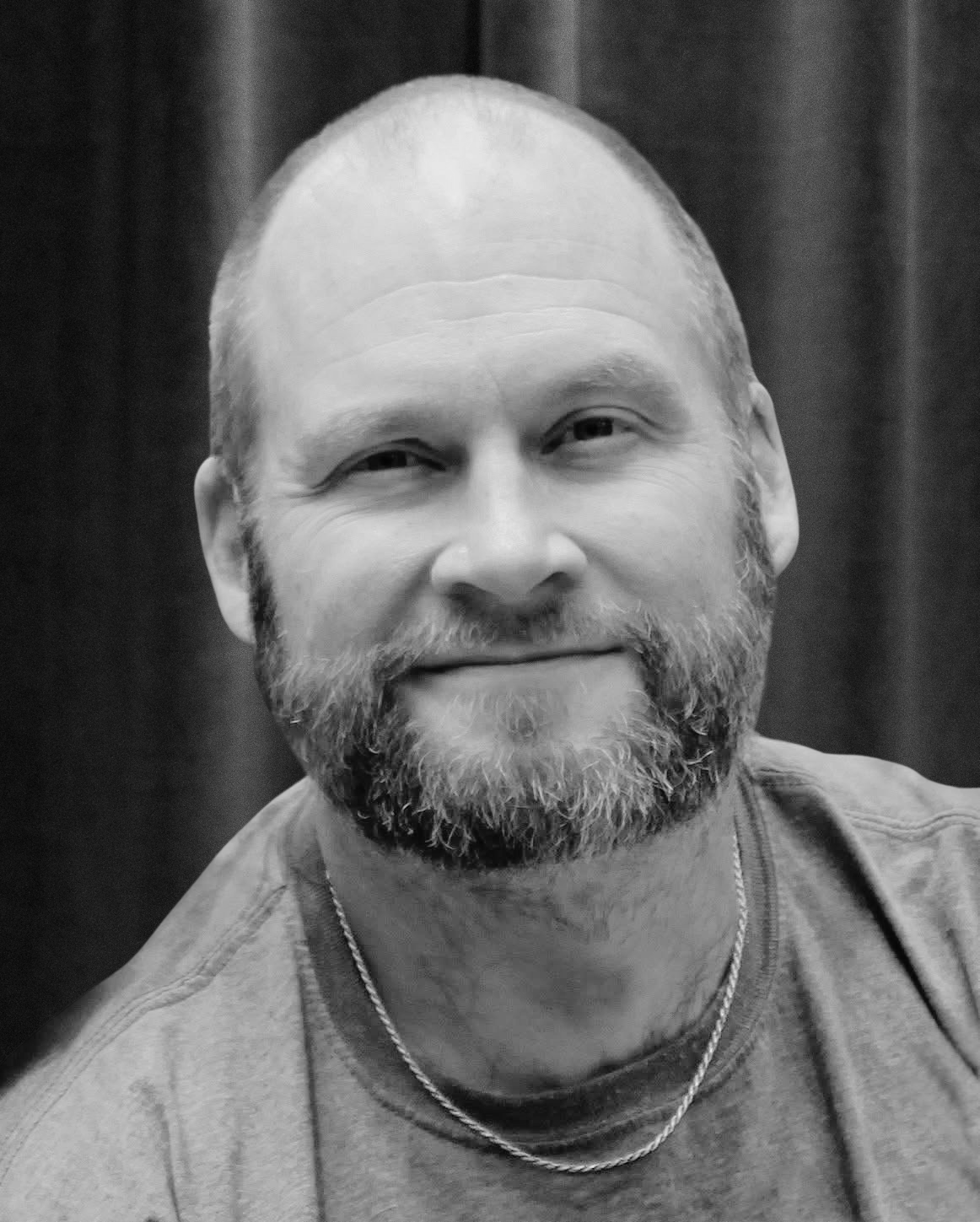 An image with a spotlight shining downward with smoke or fog swirling, and the words 'Coming Soon' in bold black text