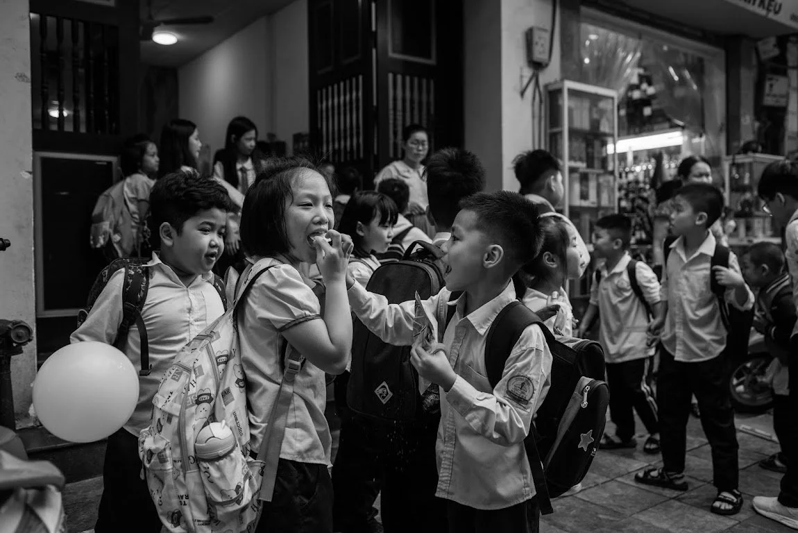 School children in uniforms gathering and talking outdoors.