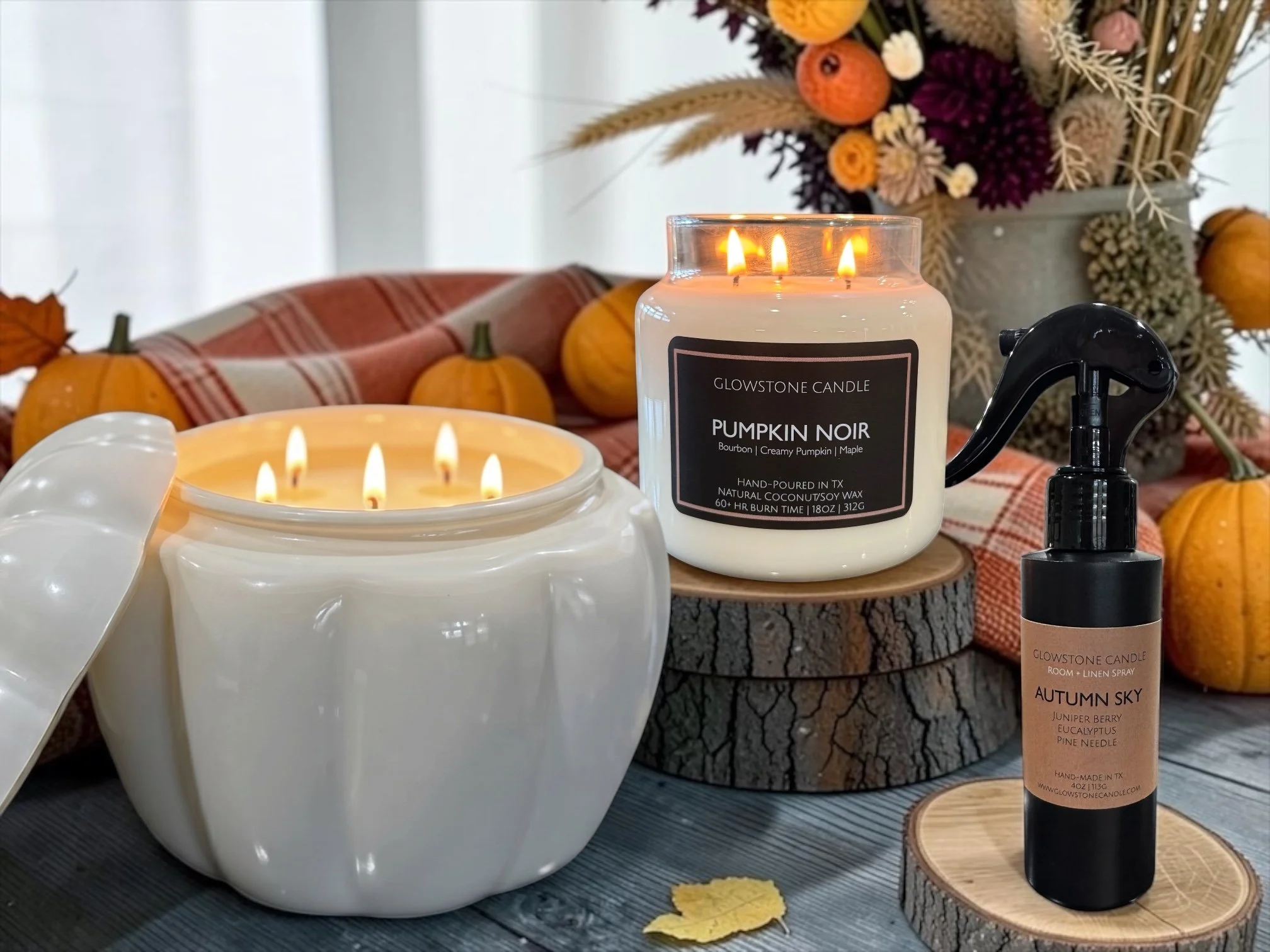 a photo of our large pumpkin candle, pumpkin noir candle and Autumn Sky room spray in s fall themed room