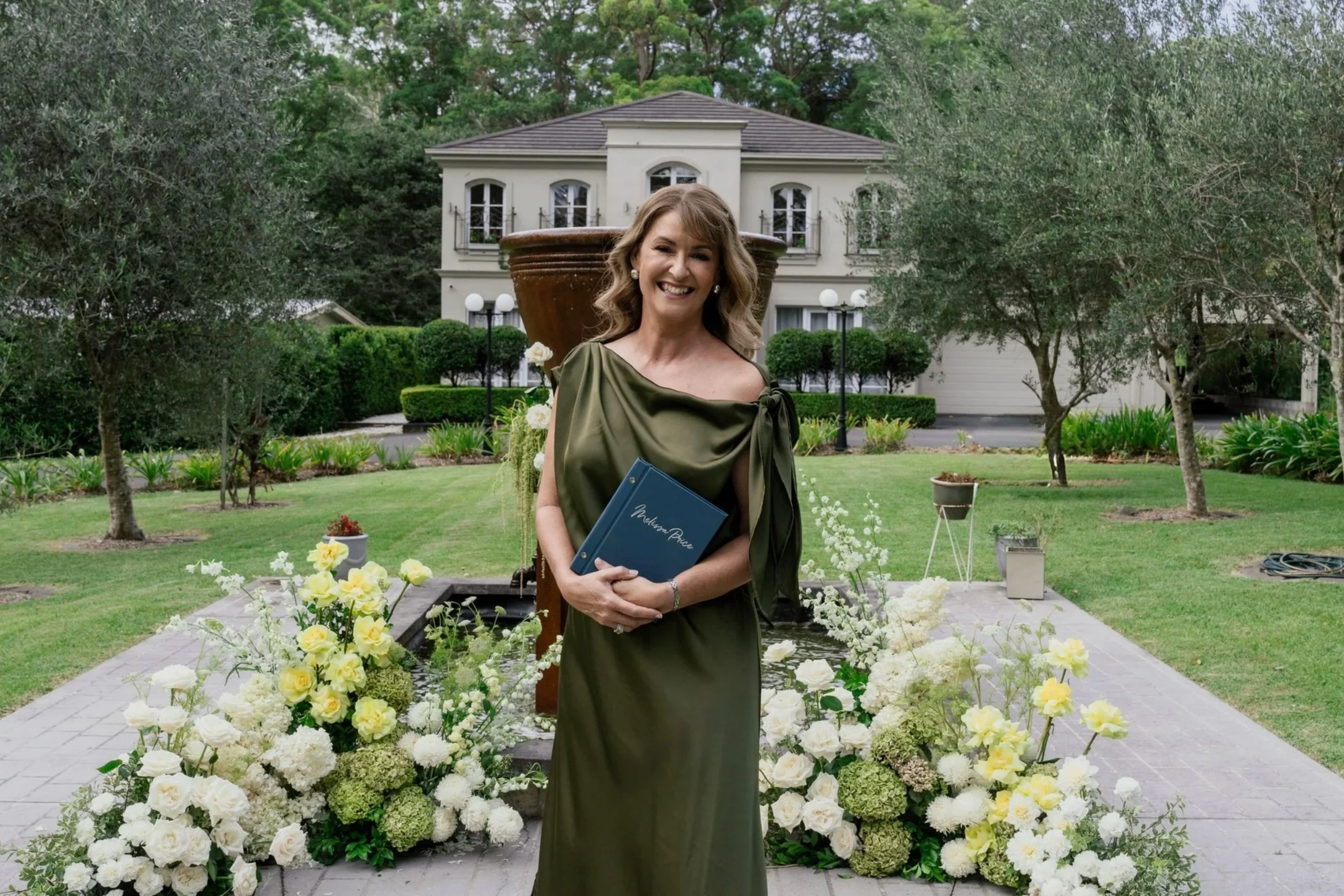 Melissa Price, Brisbane Marriage Celebrant and Master of Ceremonies, officiating an outdoor wedding ceremony at an elegant French provincial elopement venue on the Sunshine Coast, Queensland.