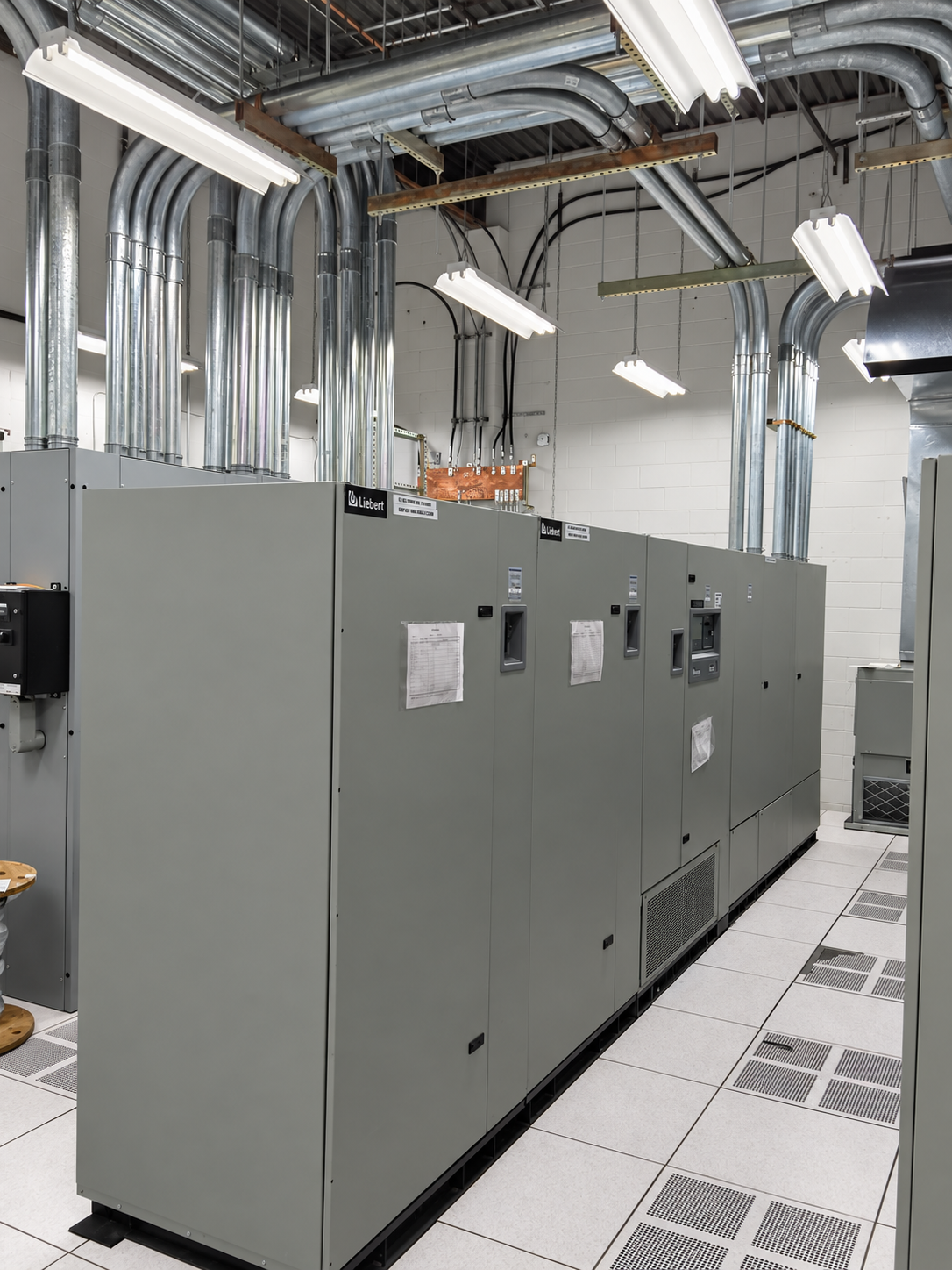 Electrical equipment room with coordinated conduits and raised-floor service access