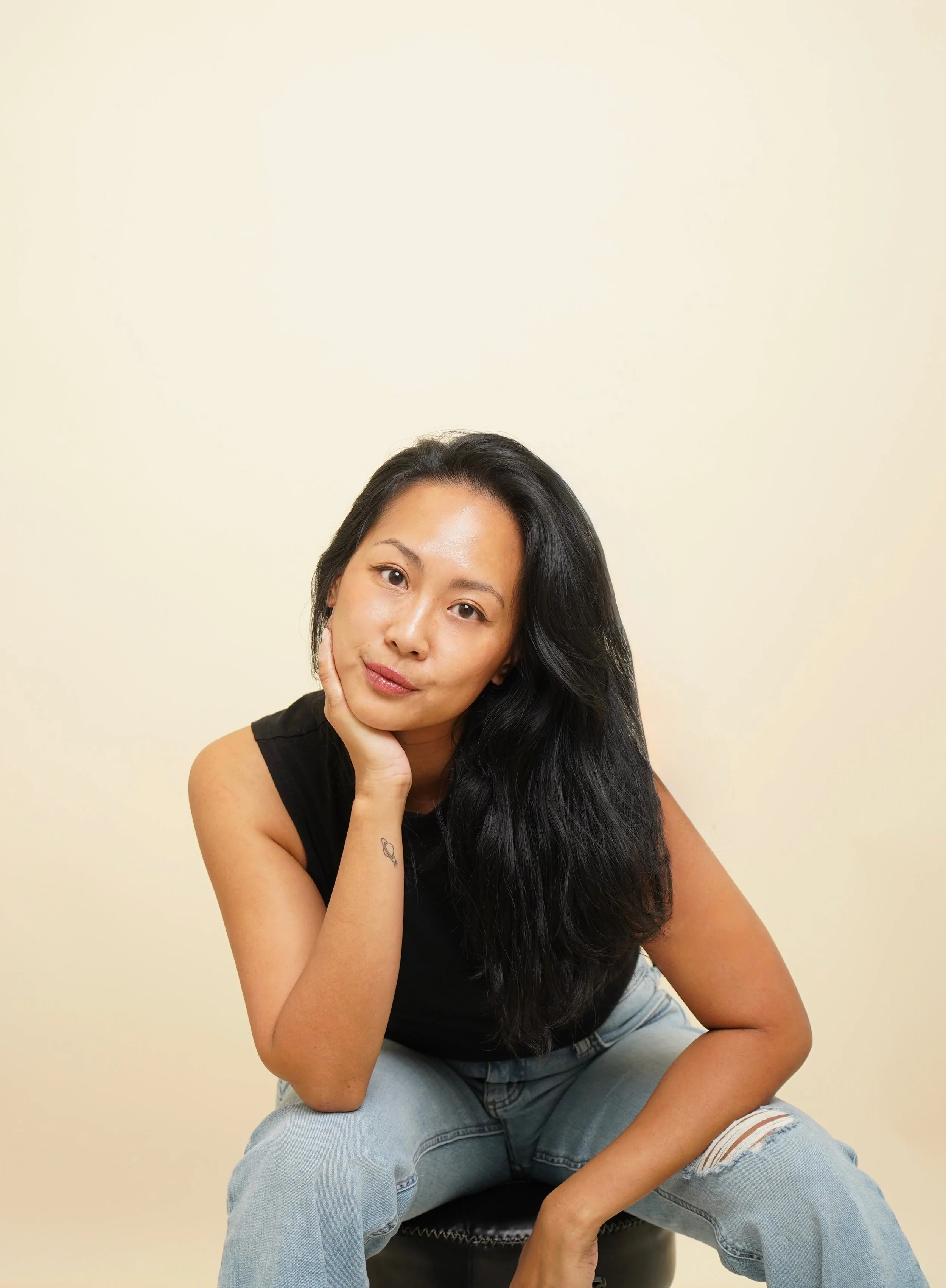 woman with black hair posing in front of camera