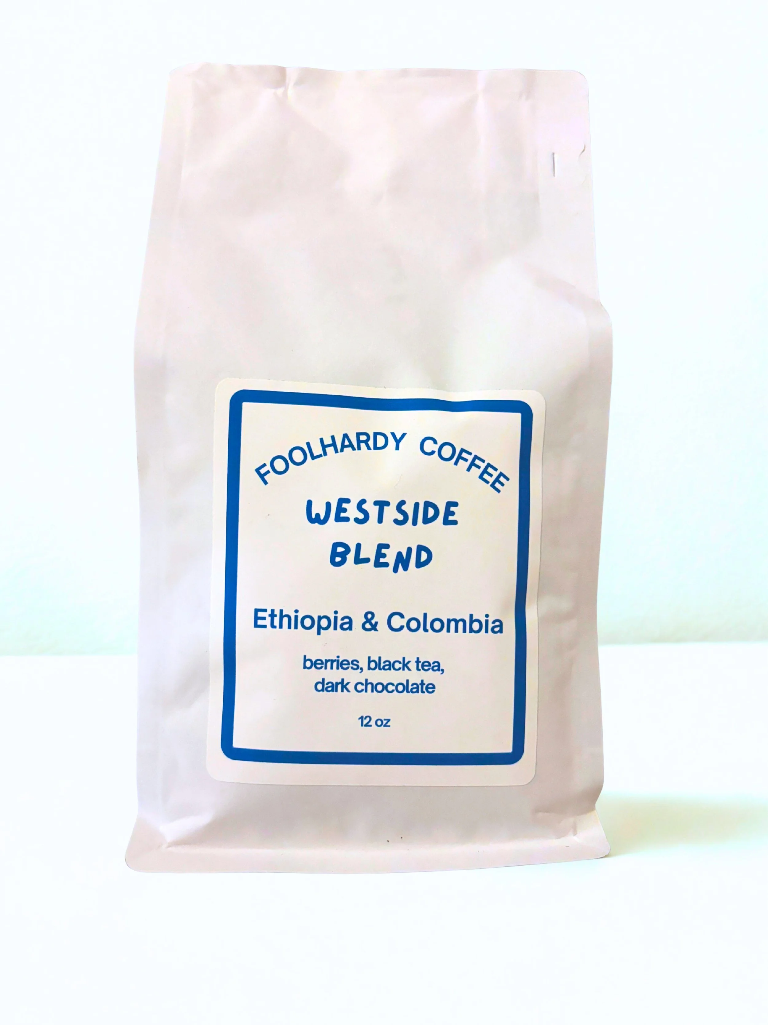 White bag of Foolhardy Coffee Westside Blend with label indicating Ethiopia and Colombia beans, containing berries, black tea, and dark chocolate, 12 oz.
