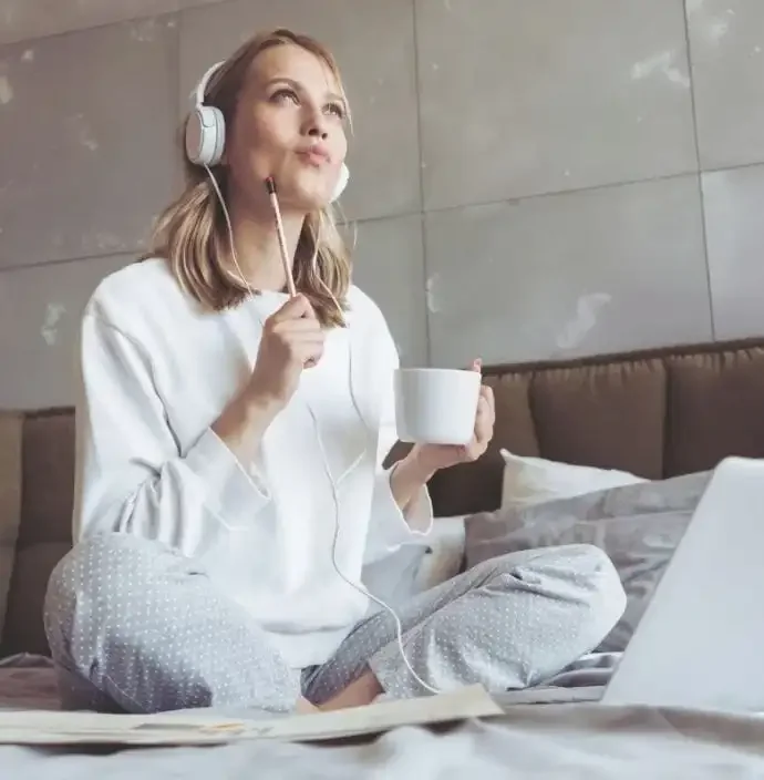 Frau mit Kopfhörern, Tasse und Stift zum Schreiben Writing