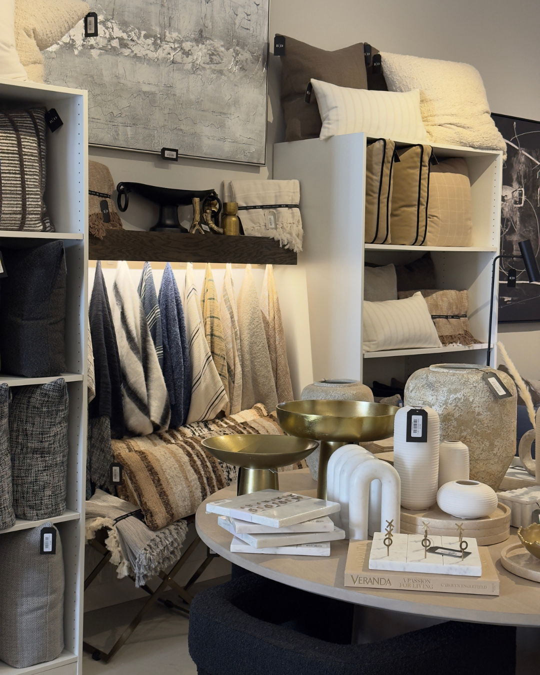 Display of home decor items including pillows, blankets, vases, bowls, and decorative accessories in a retail store. Modern furniture and home decor store in New Orleans.