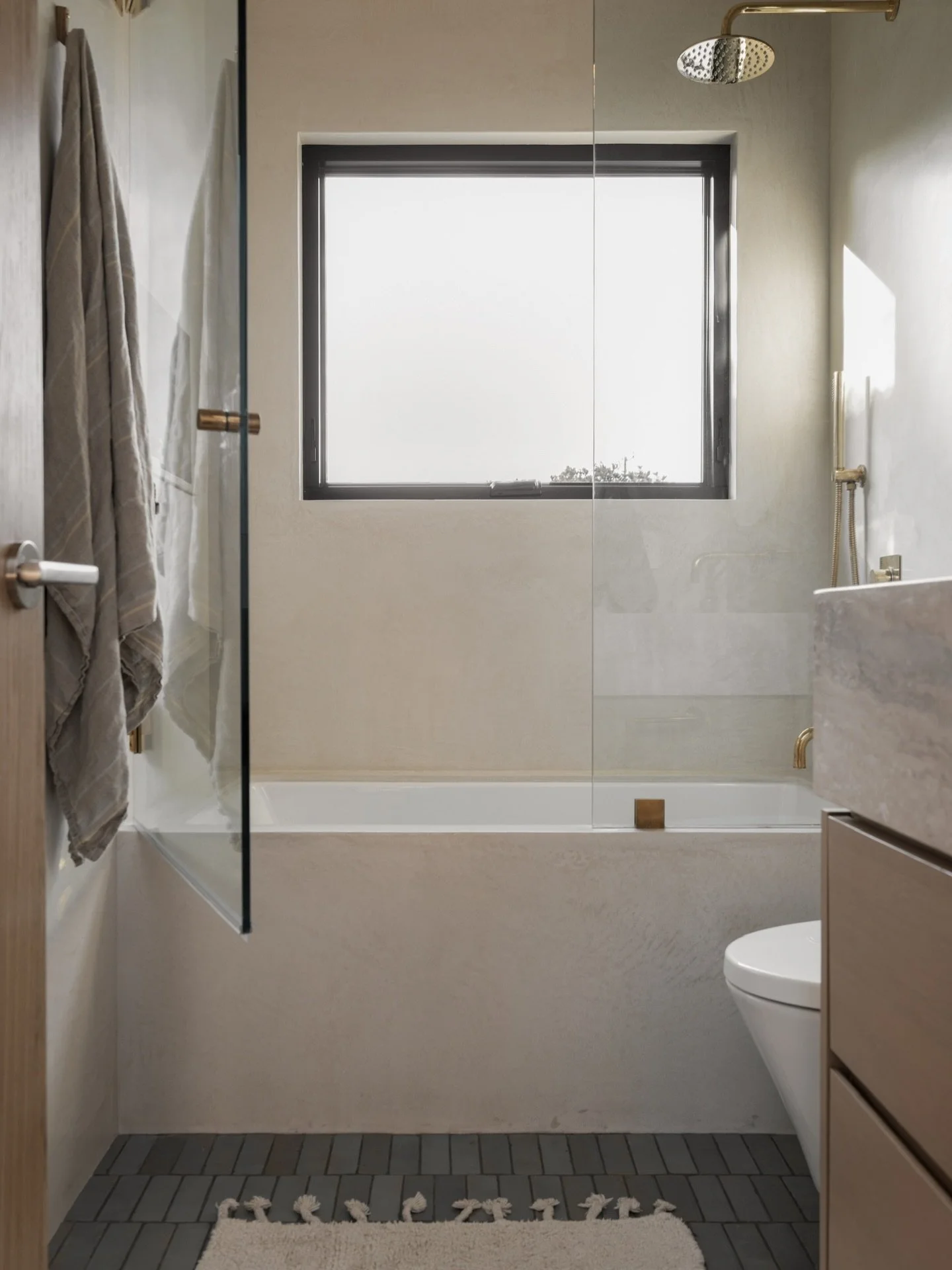 BEFORE &amp; AFTER - Small space, big impact! This bathroom might be compact, but it&rsquo;s packed with fun design details - especially with the oversized window, stunning tadelakt walls and tub surround, and blue Zellige tile flooring. More pics of