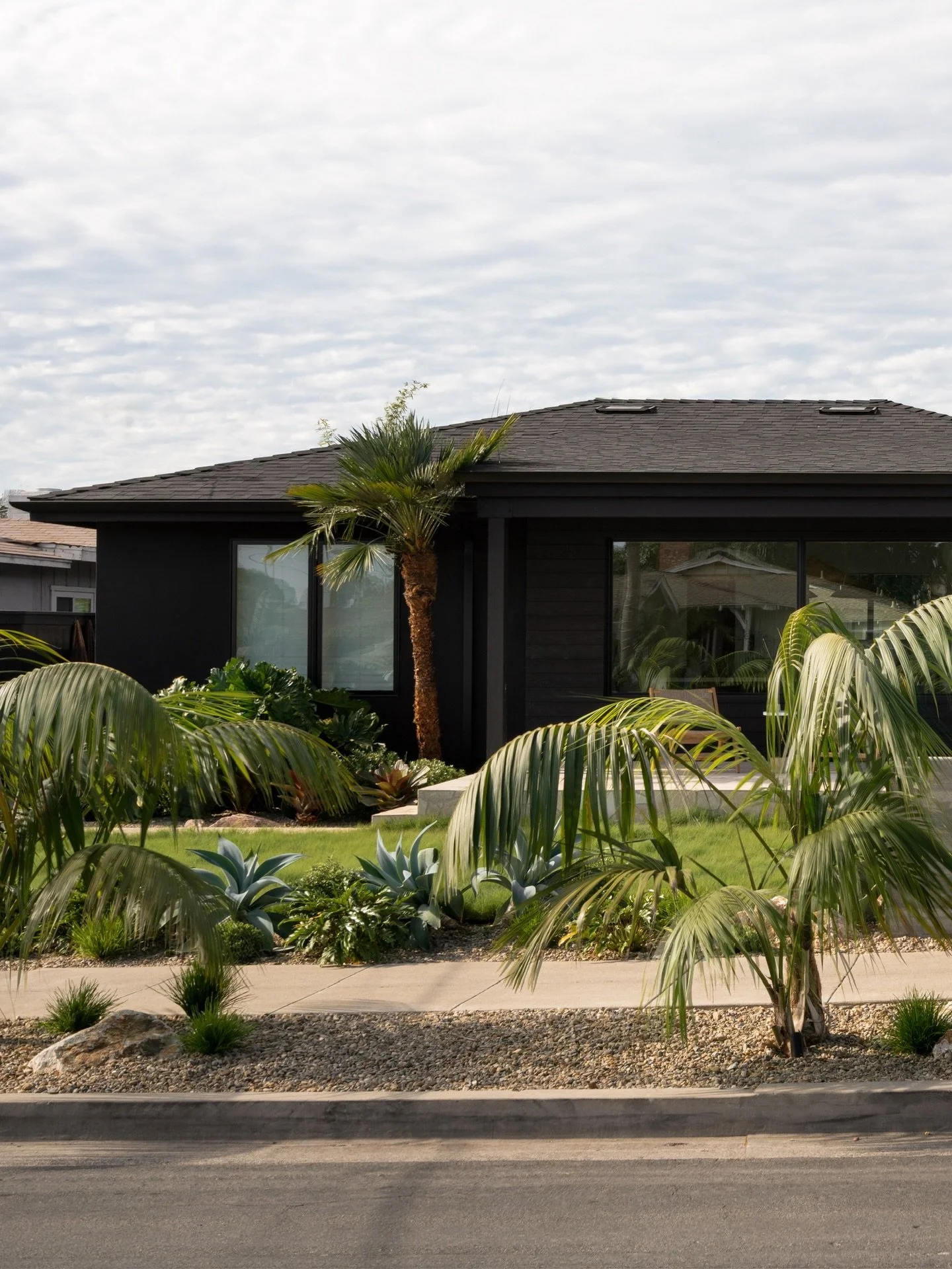 Forever in love with a black house 🖤 We softened the bold black exterior with creamy natural toned stone combinations, alabaster sconces, and lush tropical landscaping. It&rsquo;s a winning combo if you ask me! 
SWIPE for a breakdown of some of the 