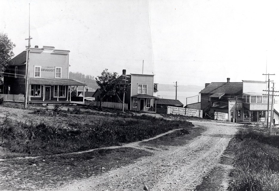 About 1925. Market Street at 26th Ave, Richmond Beach. Market Street at 26th Ave. L-R S.J. Umbrite Drugs, Post Office, Walloch's Hardware.
