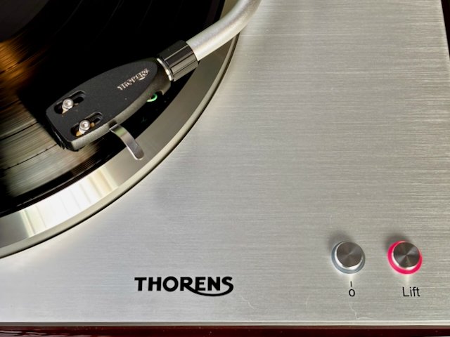 Detail view of Thorens TD 404 DD turntable showing brushed aluminum plinth, TP 160 tonearm, speed fine adjustment and illuminated lift control button.