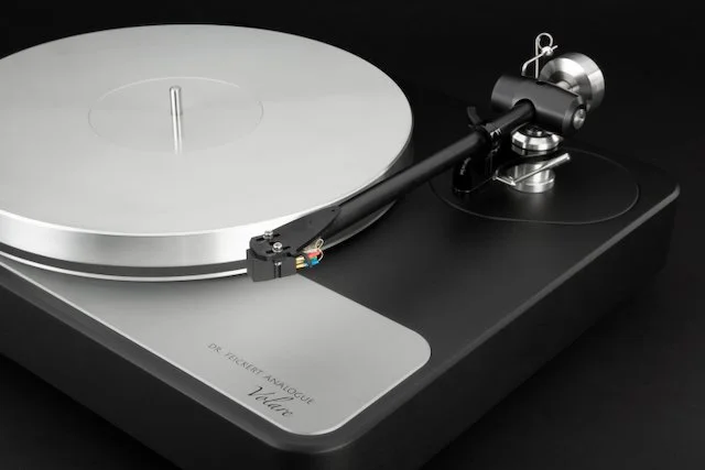 Close-up of Dr. Feickert Analogue Volare turntable in black finish, showing precision tonearm assembly, aluminum platter, and machined plinth detail.