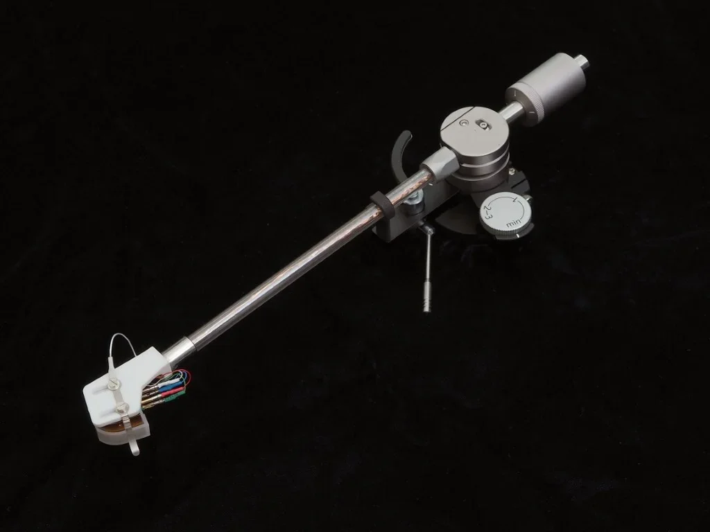 Sapphire Korf TA-CF9/10 tonearm shown in three-quarter view, featuring a sapphire arm tube, precision bearing assembly, counterweight, and white ceramic headshell against a black background.