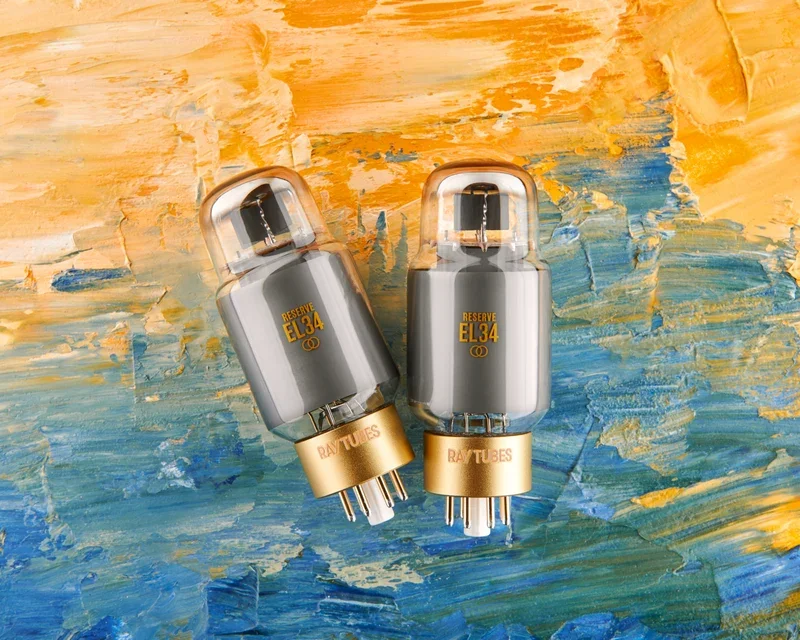 Overhead view of two Ray Tubes RESERVE EL34 vacuum tubes with metallic gray glass and orange lettering, set against an abstract oil painting.