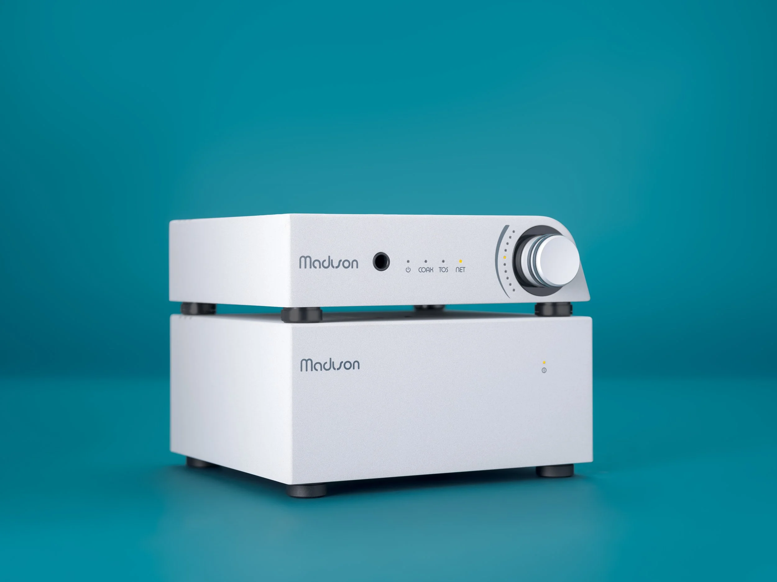 Light Gray Wattson Madison Streamer and Madison Power S stacked in a three-quarter view against a teal background, showing the matched compact chassis and clean minimalist design.