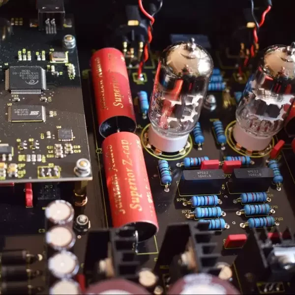 Close-up inside the Lab12 dac1 reference showing dual vacuum tubes, premium capacitors, the digital processing board, and carefully laid out analog circuitry.