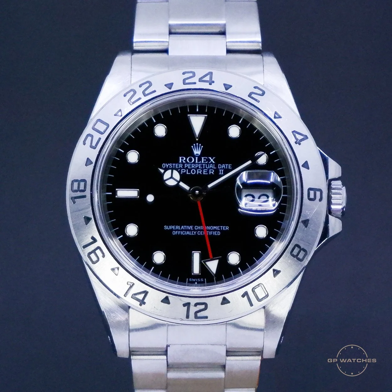 A silver Rolex Explorer II wristwatch with a black dial, white hour markers, and a date window showing the 22nd, against a black background.